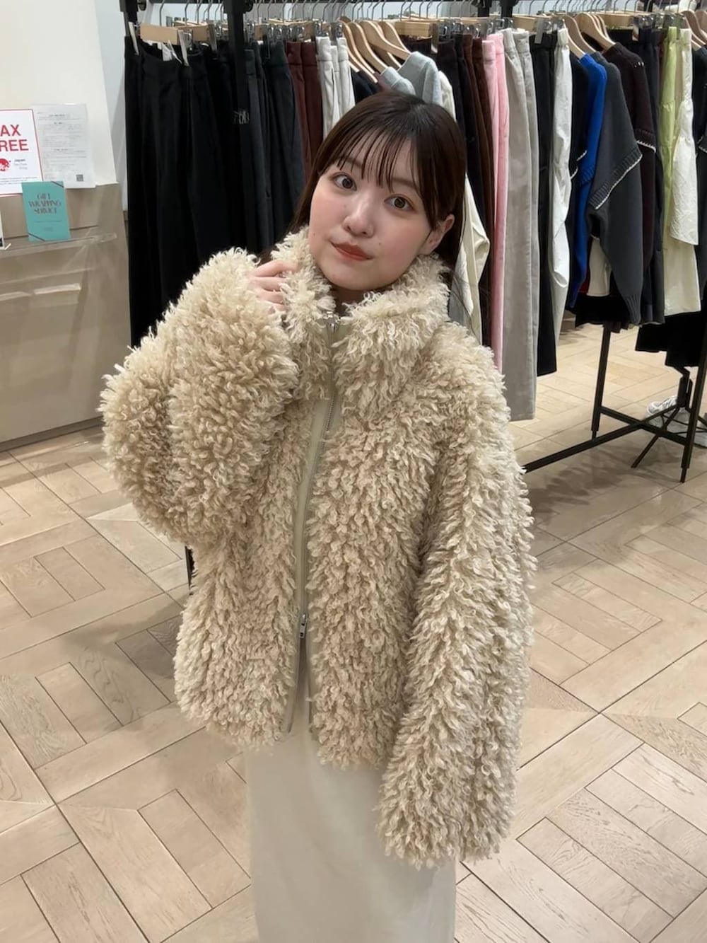 ホワイト系のブルゾンを着用したレディースの冬コーディネートの2枚目の写真