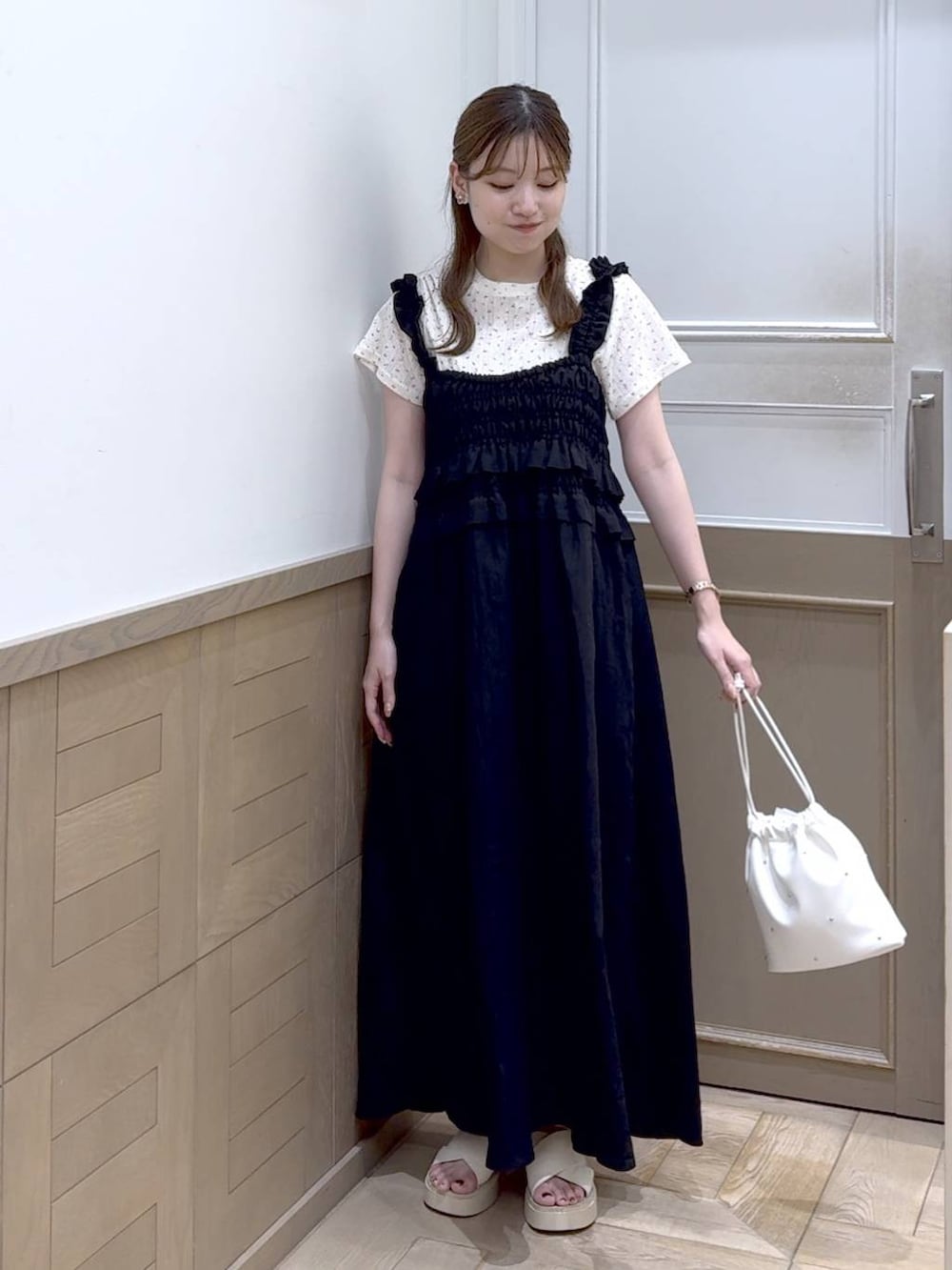 ホワイト系のショルダーバッグ、ホワイト系のサンダル、ブラック系のワンピースを着用したレディースの夏コーディネートの5枚目の写真