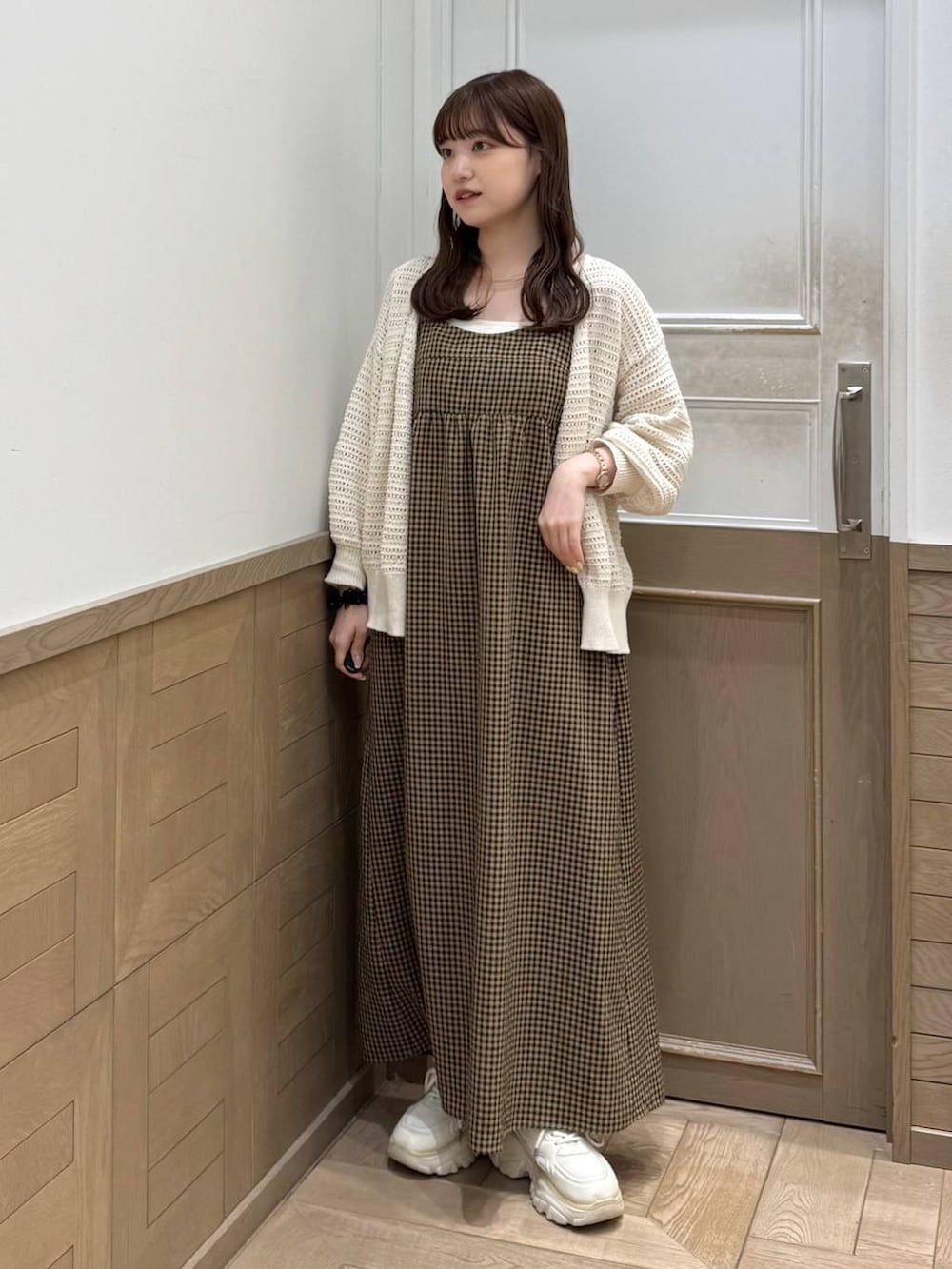 ホワイト系のスニーカー、ベージュ系のワンピース、ホワイト系のカーディガン/ボレロを着用したレディースの春コーディネートの3枚目の写真