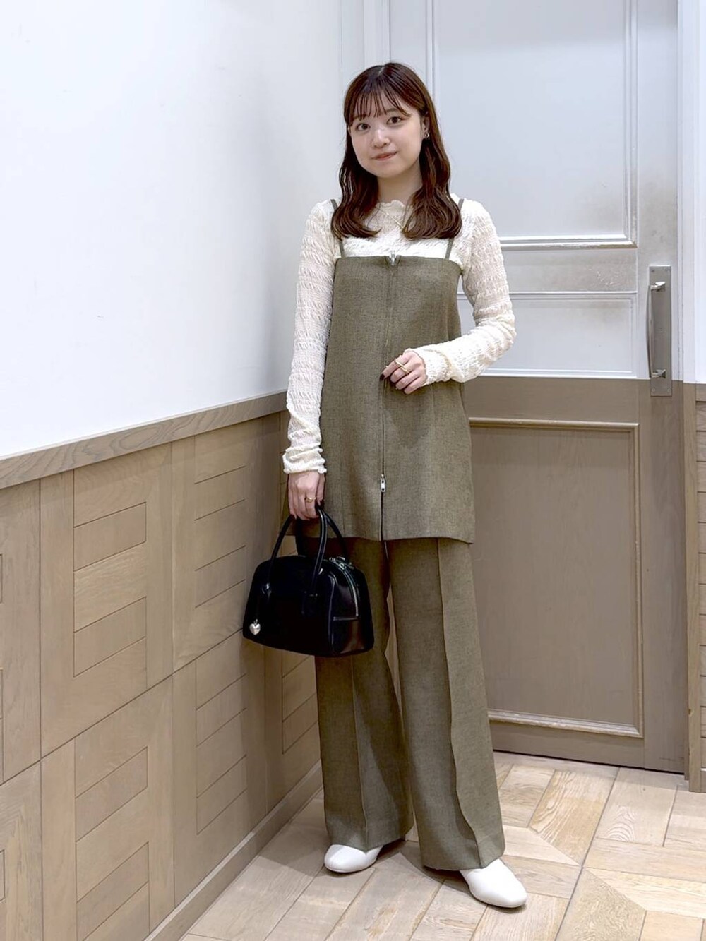 ホワイト系のTシャツ/カットソー、ホワイト系のブーツ、ブラック系のボストンバッグを着用したレディースの秋コーディネートの4枚目の写真