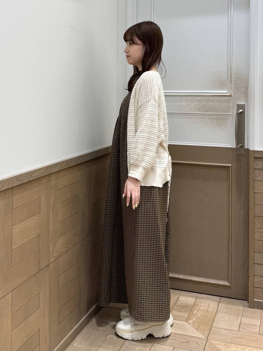 ホワイト系のスニーカー、ベージュ系のワンピース、ホワイト系のカーディガン/ボレロを着用したレディースの春コーディネートの4枚目の写真