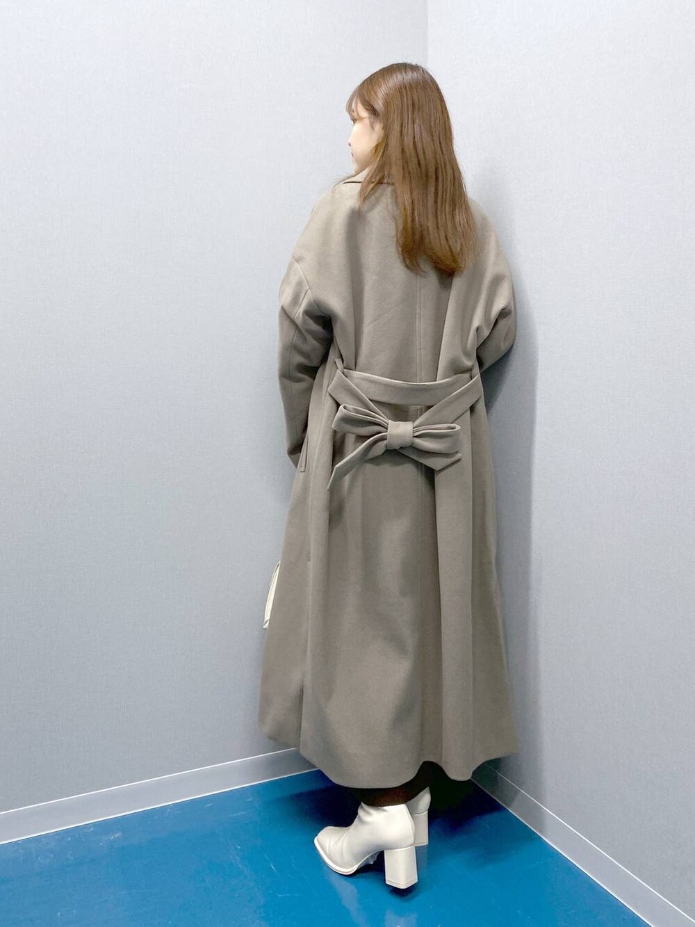 ホワイト系のTシャツ/カットソー、ホワイト系のショルダーバッグ、ブラウン系のトレンチコートを着用したレディースの冬コーディネートの2枚目の写真