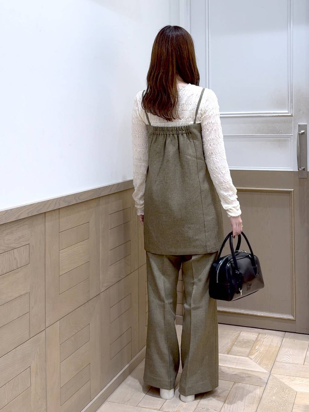 ホワイト系のTシャツ/カットソー、ホワイト系のブーツ、ブラック系のボストンバッグを着用したレディースの秋コーディネートの3枚目の写真