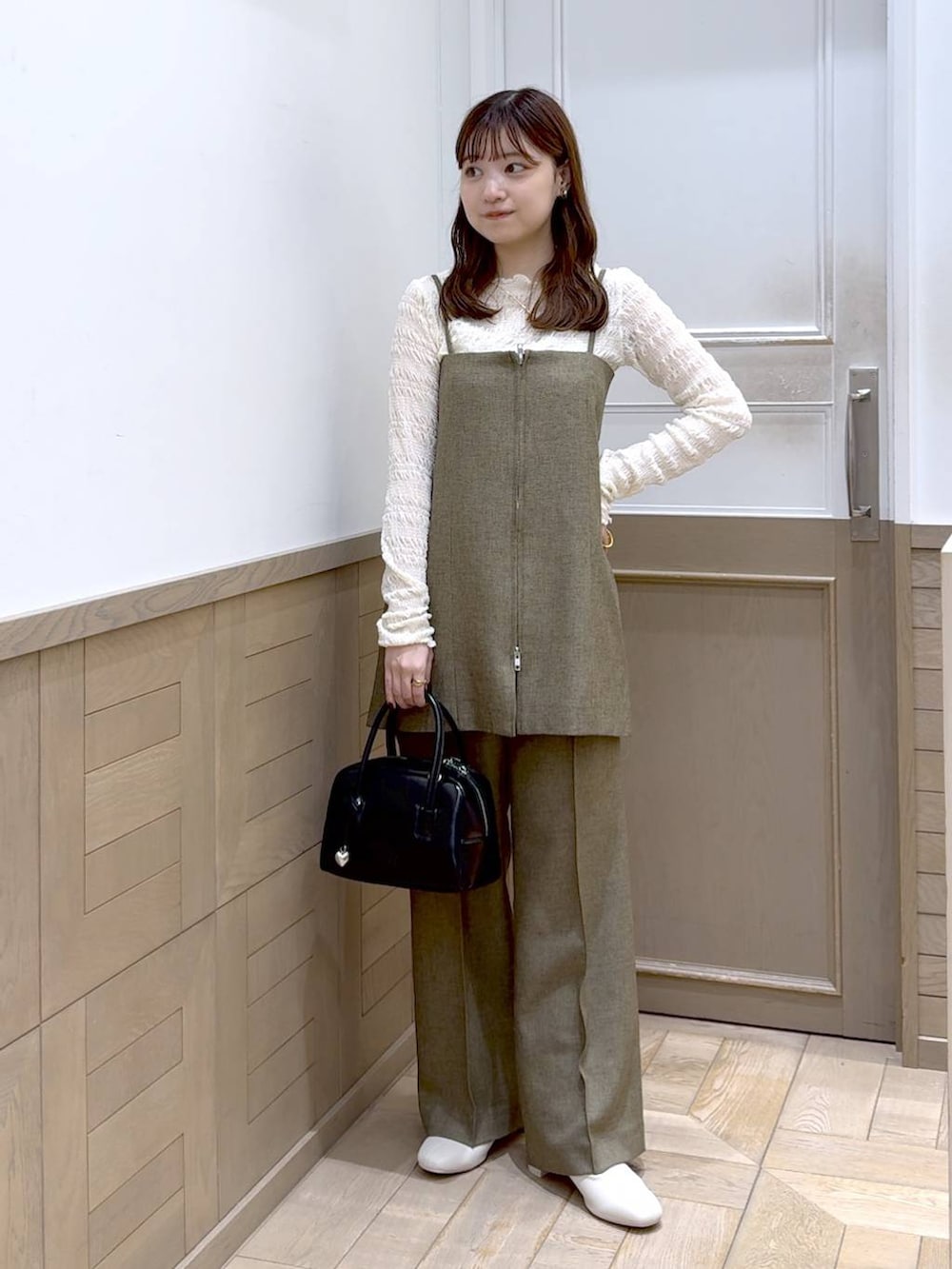 ホワイト系のTシャツ/カットソー、ホワイト系のブーツ、ブラック系のボストンバッグを着用したレディースの秋コーディネートの5枚目の写真