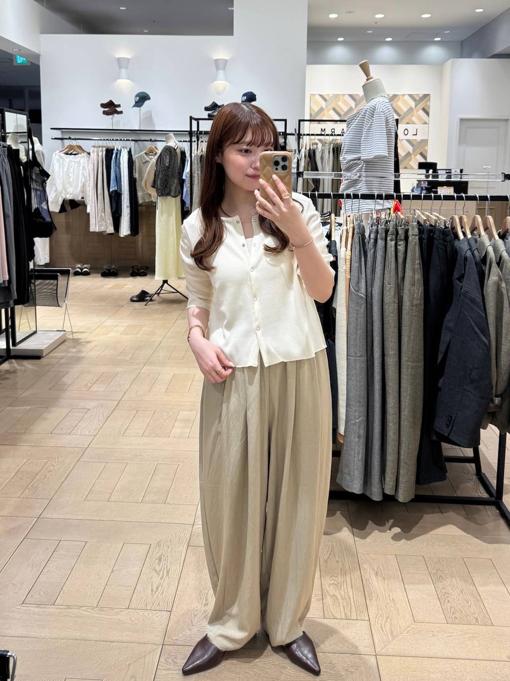 ブラウン系のサンダル、ベージュ系のその他パンツ、ホワイト系のTシャツ/カットソーを着用したレディースの春コーディネートの3枚目の写真
