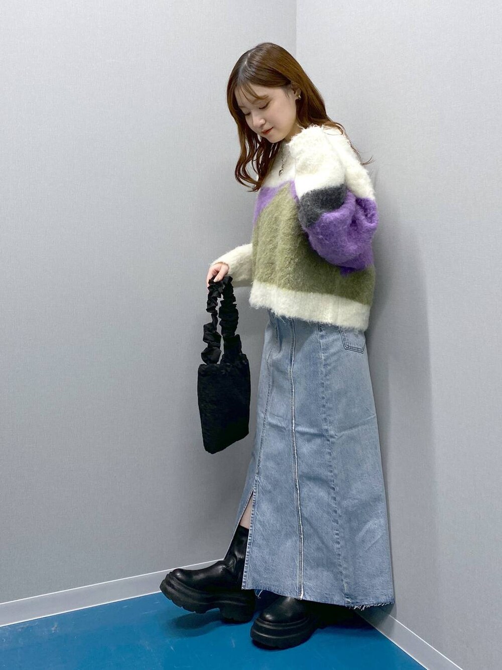 ブラック系のブーツ、ブラック系のショルダーバッグ、パープル系のニット/セーターを着用したレディースの冬コーディネートの2枚目の写真