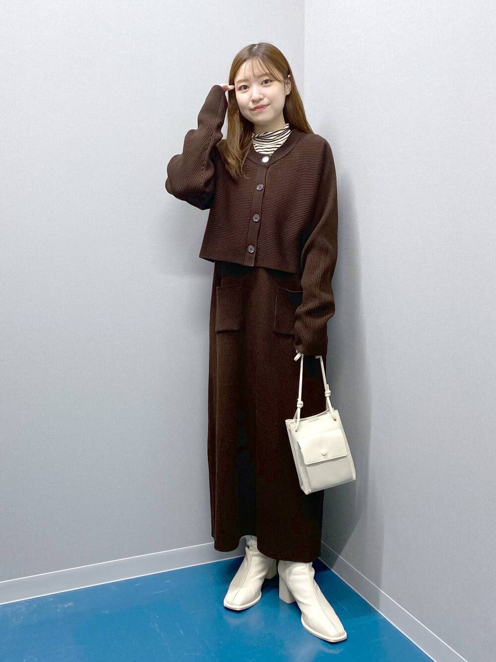 ホワイト系のTシャツ/カットソー、ホワイト系のショルダーバッグ、ブラウン系のトレンチコートを着用したレディースの冬コーディネートの3枚目の写真