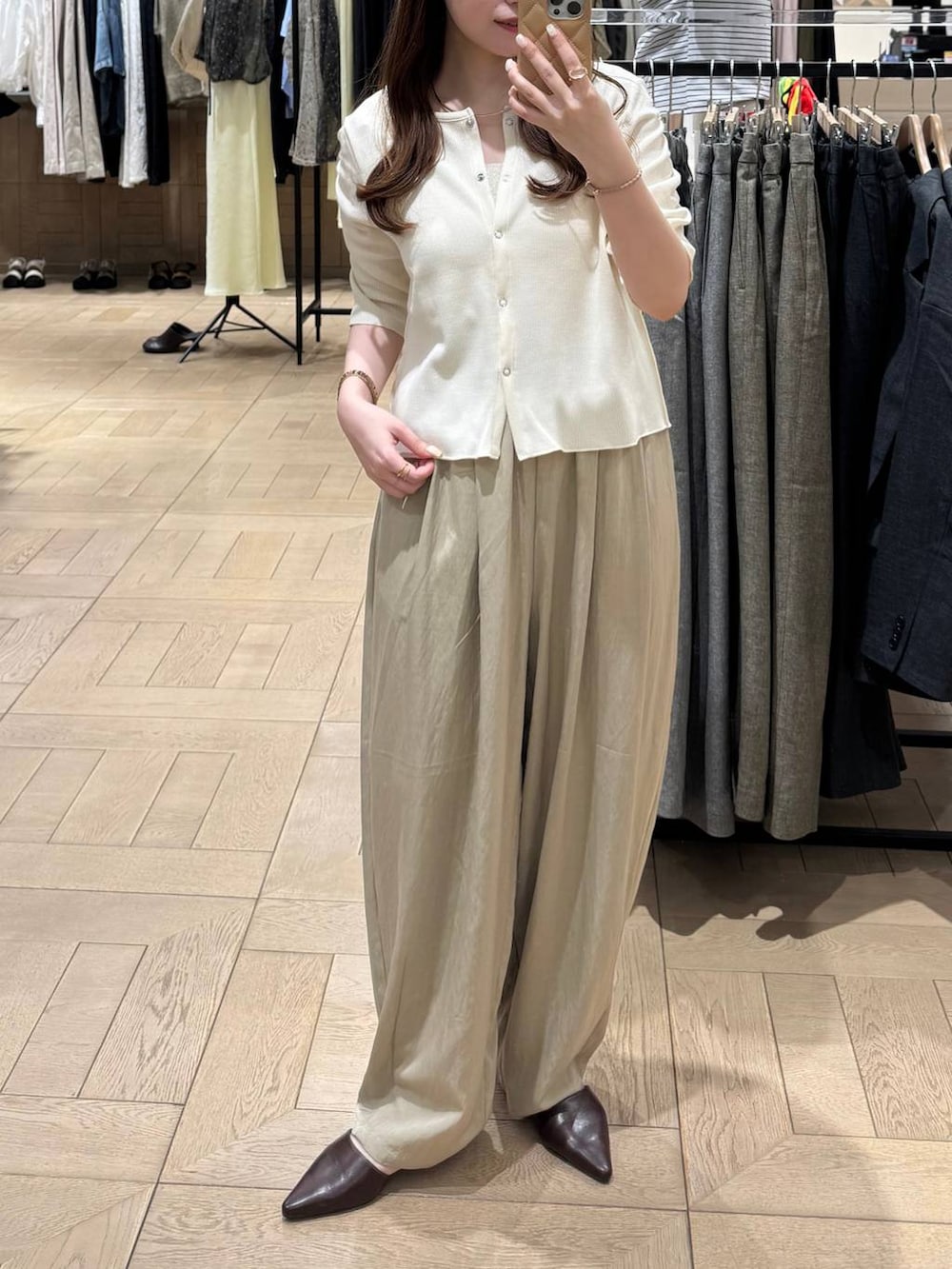 ブラウン系のサンダル、ベージュ系のその他パンツ、ホワイト系のTシャツ/カットソーを着用したレディースの春コーディネートの2枚目の写真