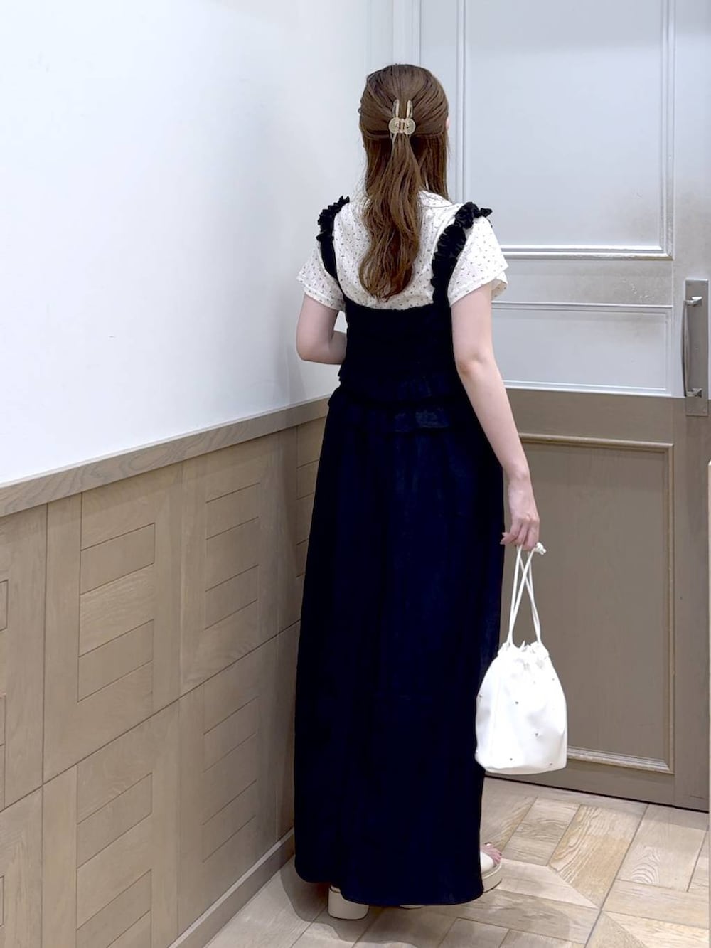 ホワイト系のショルダーバッグ、ホワイト系のサンダル、ブラック系のワンピースを着用したレディースの夏コーディネートの4枚目の写真