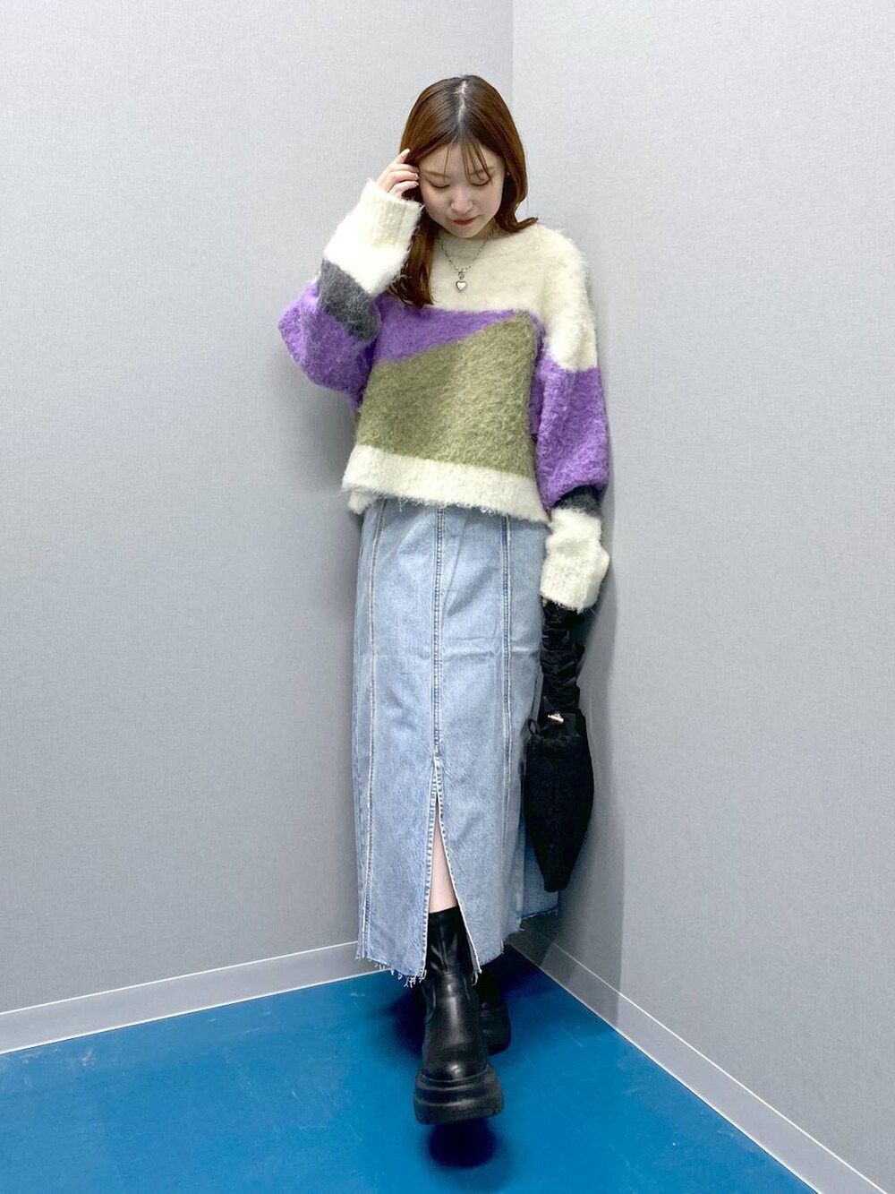 ブラック系のブーツ、ブラック系のショルダーバッグ、パープル系のニット/セーターを着用したレディースの冬コーディネートの6枚目の写真