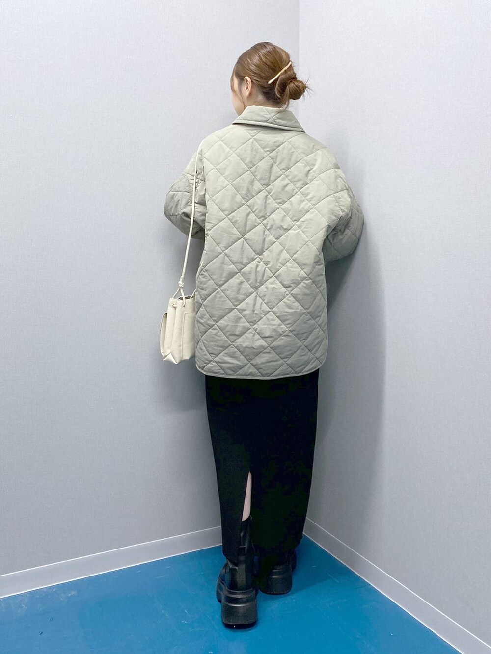 ホワイト系のショルダーバッグ、ブラック系のブーツ、ブラック系のスカートを着用したレディースの冬コーディネートの5枚目の写真