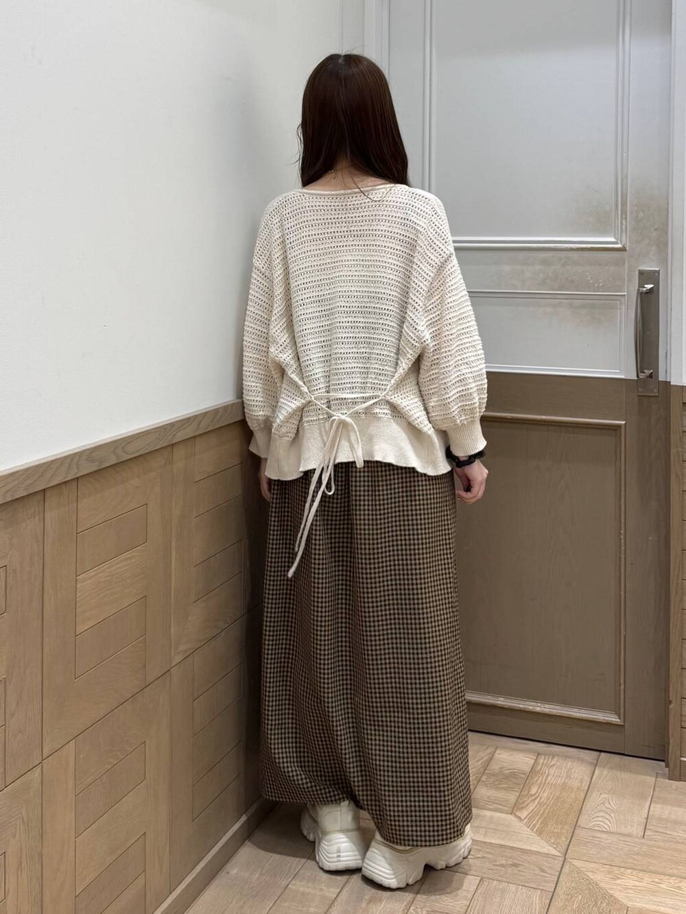 ホワイト系のスニーカー、ベージュ系のワンピース、ホワイト系のカーディガン/ボレロを着用したレディースの春コーディネートの5枚目の写真