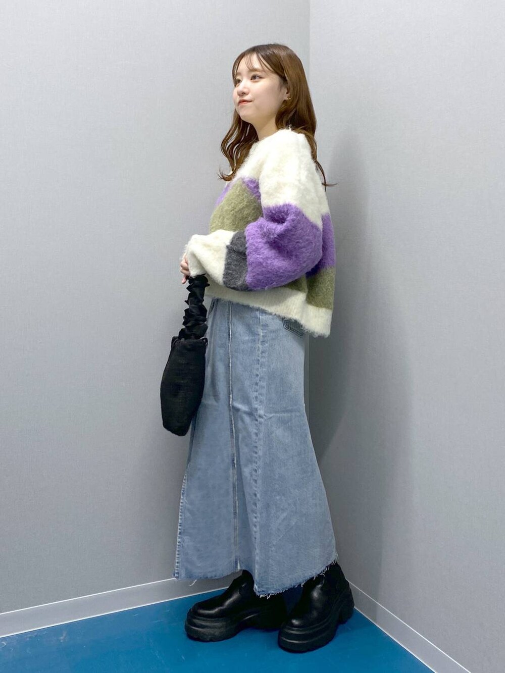 ブラック系のブーツ、ブラック系のショルダーバッグ、パープル系のニット/セーターを着用したレディースの冬コーディネートの5枚目の写真