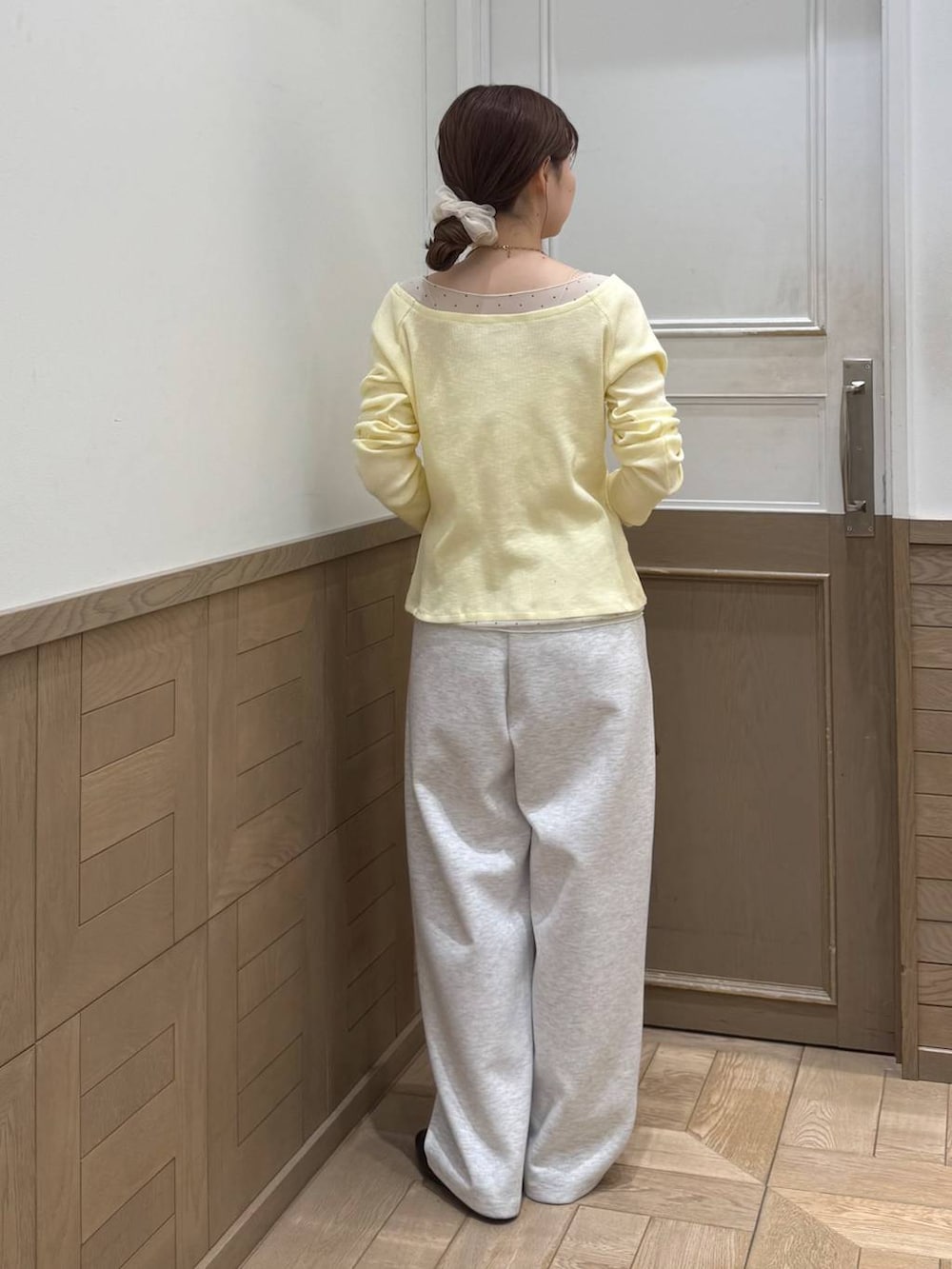 グレー系のスウェットパンツ、ブラウン系のショルダーバッグ、イエロー系のTシャツ/カットソーを着用したレディースの冬コーディネートの4枚目の写真