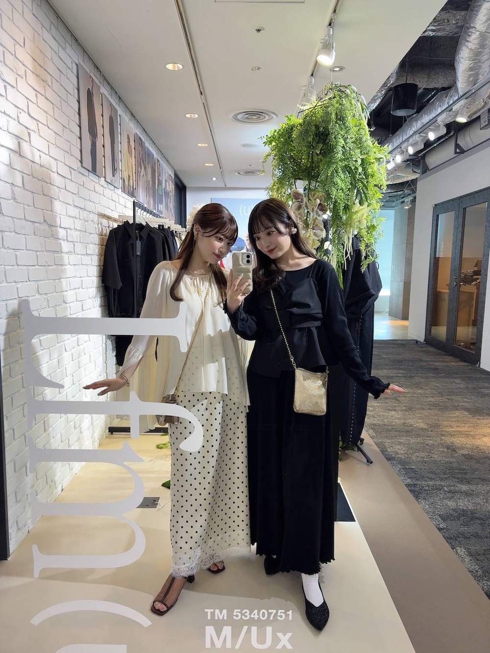 ゴールド系のショルダーバッグ、ホワイト系のスカートを着用したレディースの春コーディネートの2枚目の写真