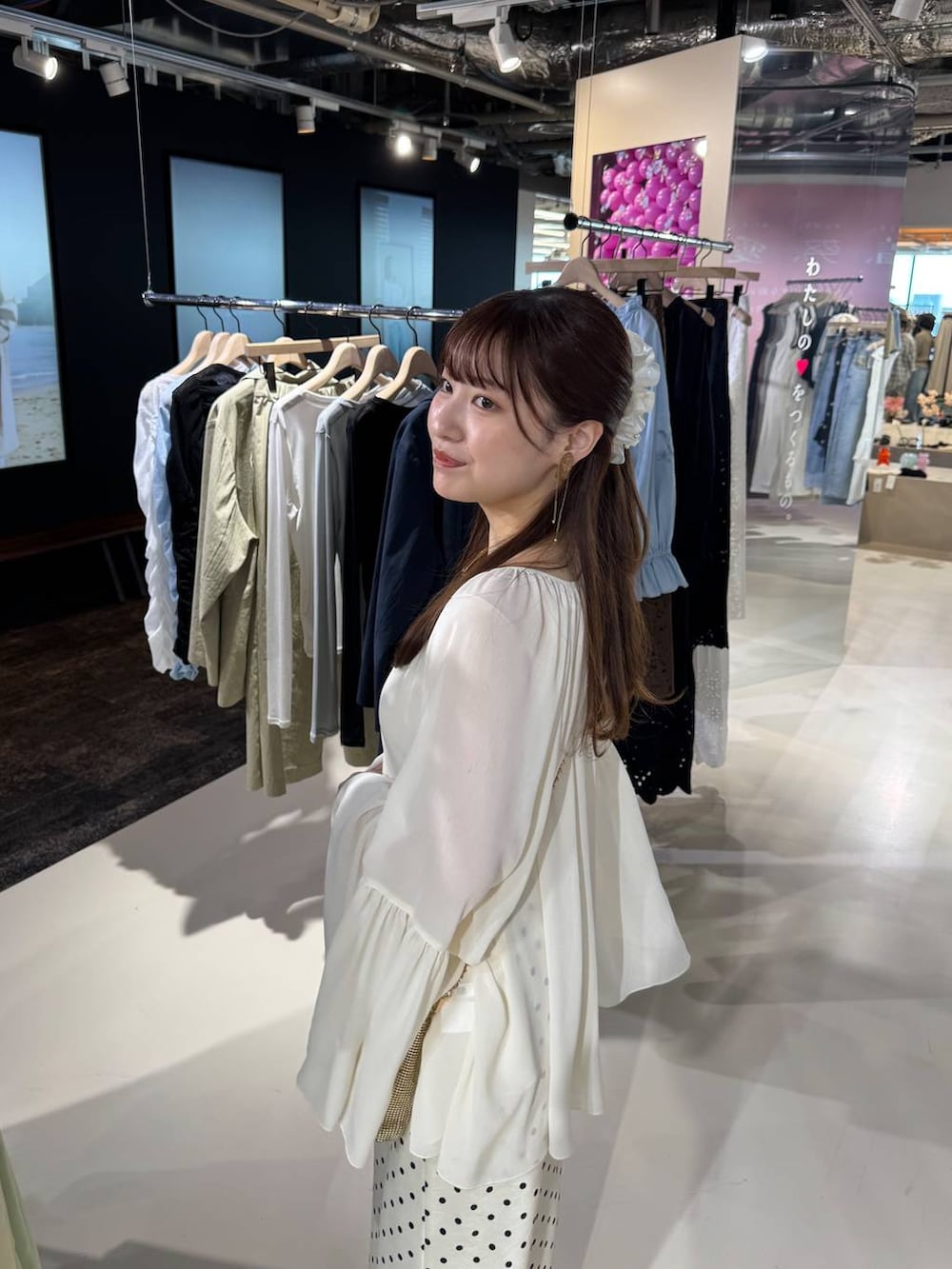 ゴールド系のショルダーバッグ、ブラウン系のサンダル、ホワイト系のスカートを着用したレディースの春コーディネートの5枚目の写真