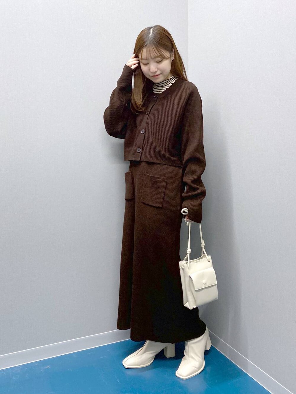 ホワイト系のTシャツ/カットソー、ホワイト系のショルダーバッグ、ブラウン系のトレンチコートを着用したレディースの冬コーディネートの4枚目の写真