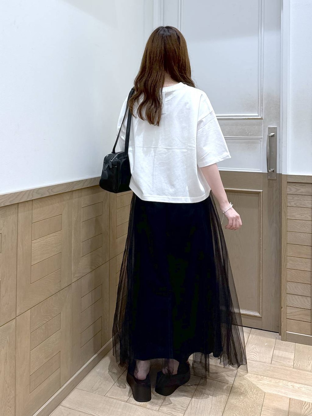 ブラック系のハンドバッグ、ブラック系のサンダル、ブラック系のスカートを着用したレディースの夏コーディネートの3枚目の写真