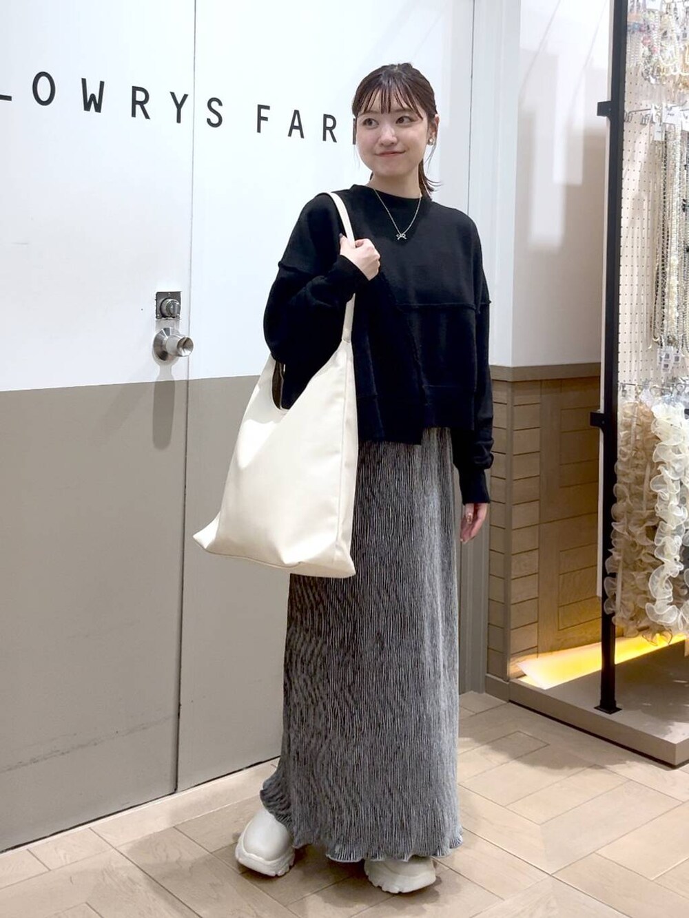 ホワイト系のショルダーバッグ、グレー系のスウェット、ホワイト系のブーツを着用したレディースの秋コーディネートの3枚目の写真