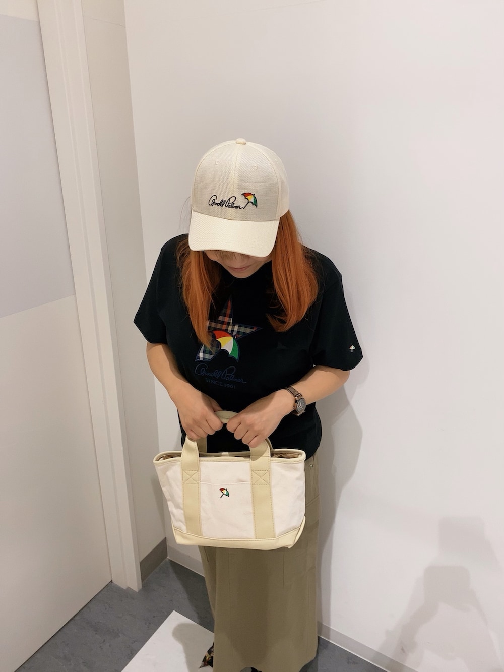 ベージュ系のトートバッグ、ブラック系のTシャツ/カットソー、グリーン系のスカートを着用したレディースの春コーディネートの3枚目の写真