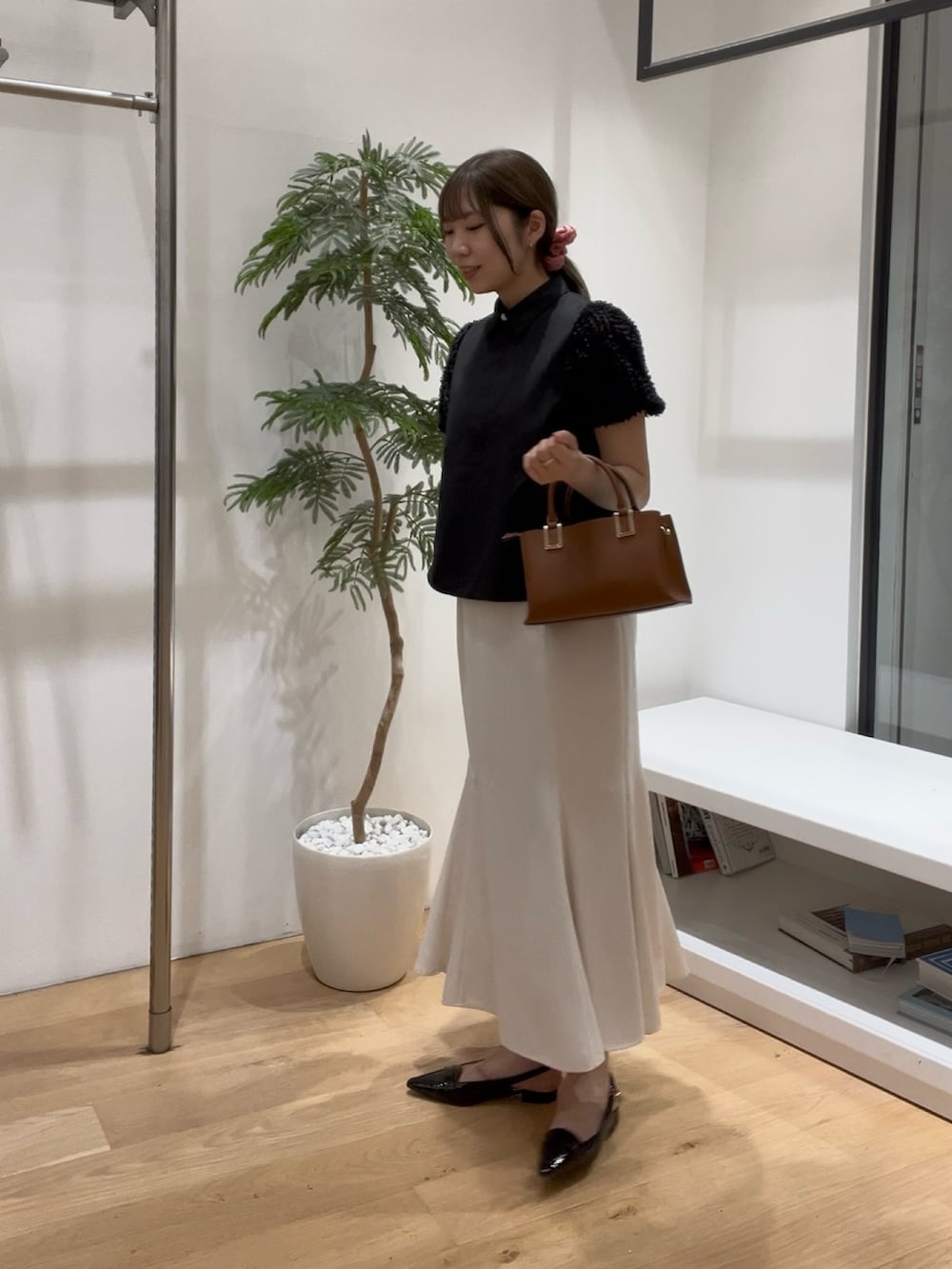 ブラック系のシャツ/ブラウス、ホワイト系のスカート、ブラック系のローファーを着用したレディースの夏コーディネートの4枚目の写真