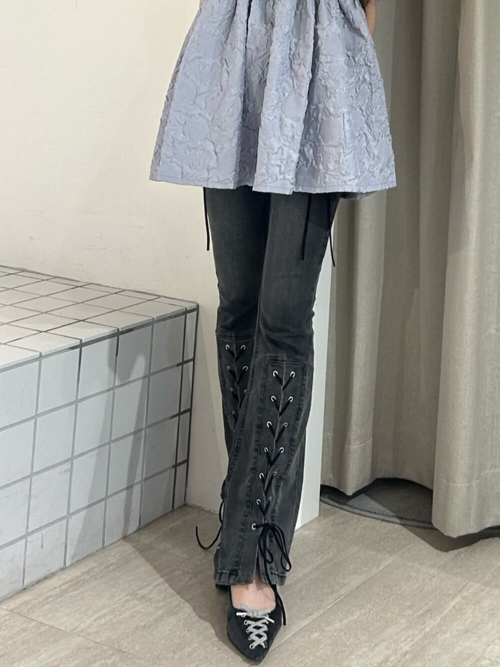 ブラック系のパンプス、ホワイト系のキャミソール、ブラック系のデニムパンツを着用したレディースの夏コーディネートの6枚目の写真