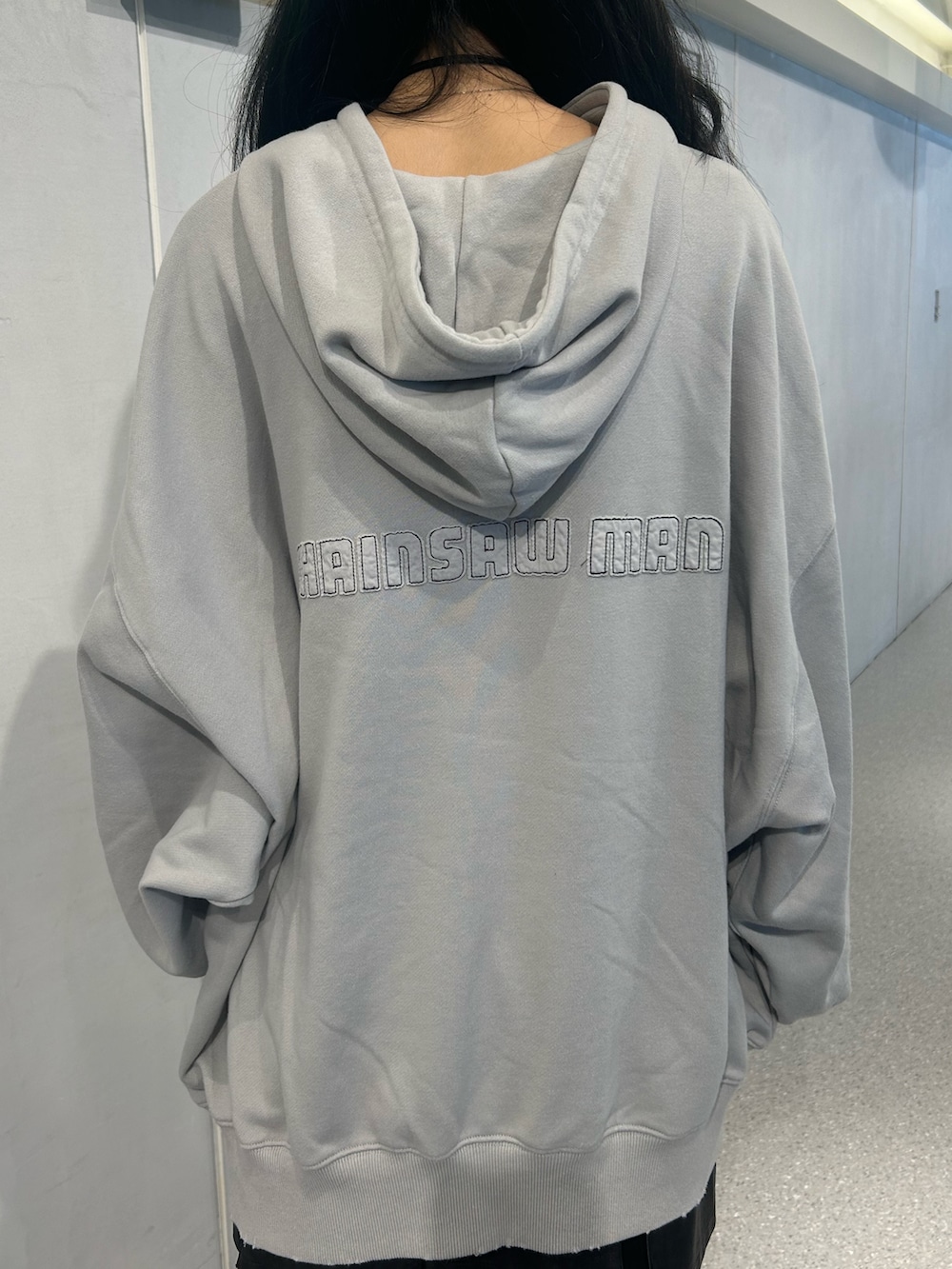 ブルー系のパーカー、ブラック系のスカート、ブルー系のブーツを着用したレディースの秋コーディネートの8枚目の写真