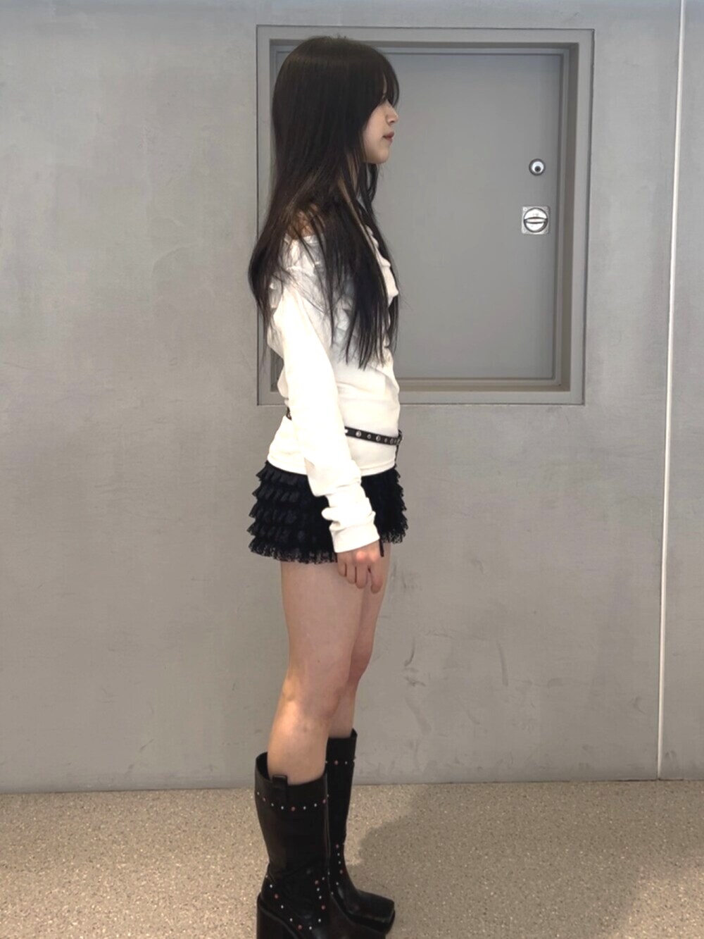 ブラック系のその他パンツ、ブラック系のブーツ、ホワイト系のTシャツ/カットソーを着用したレディースの春コーディネートの2枚目の写真