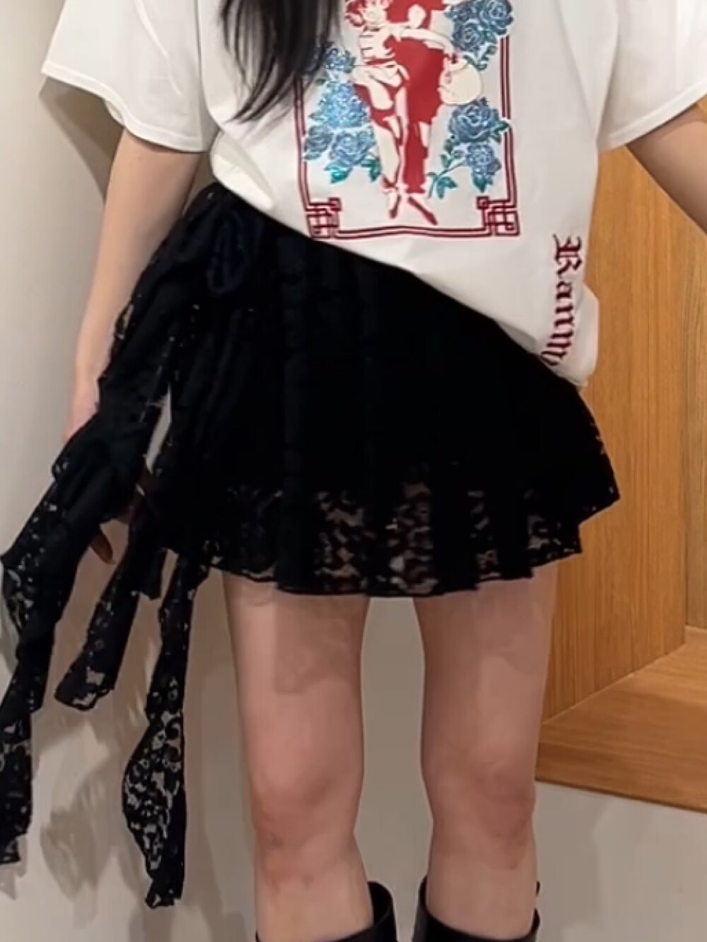 ホワイト系のTシャツ/カットソー、ブラック系のスカート、ブラック系のブーツを着用したレディースの夏コーディネートの7枚目の写真
