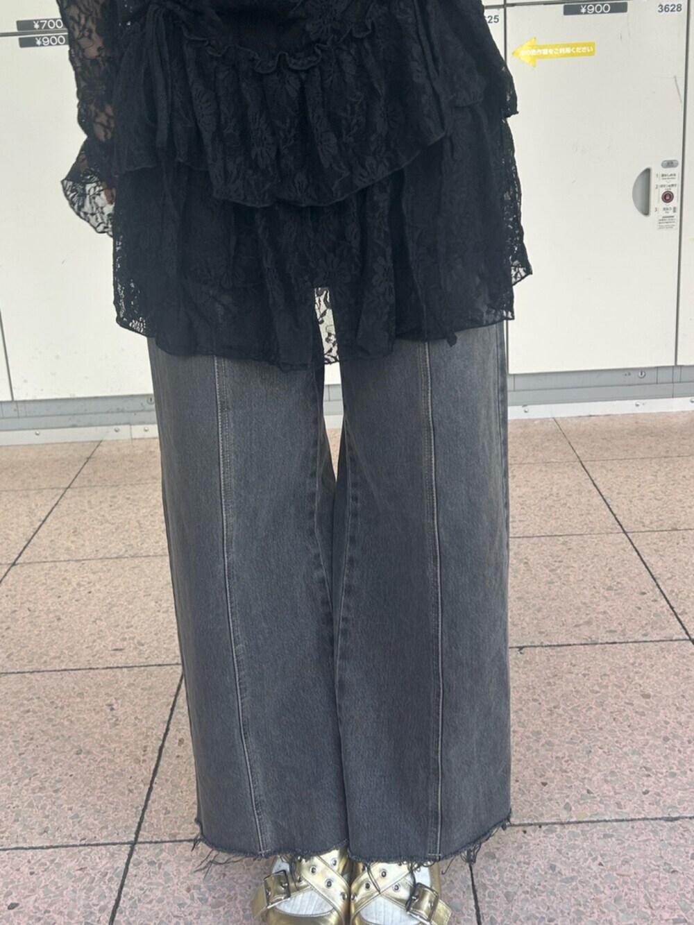 ゴールド系のパンプス、ブラック系のワンピース、ブラック系のデニムパンツを着用したレディースの冬コーディネートの7枚目の写真