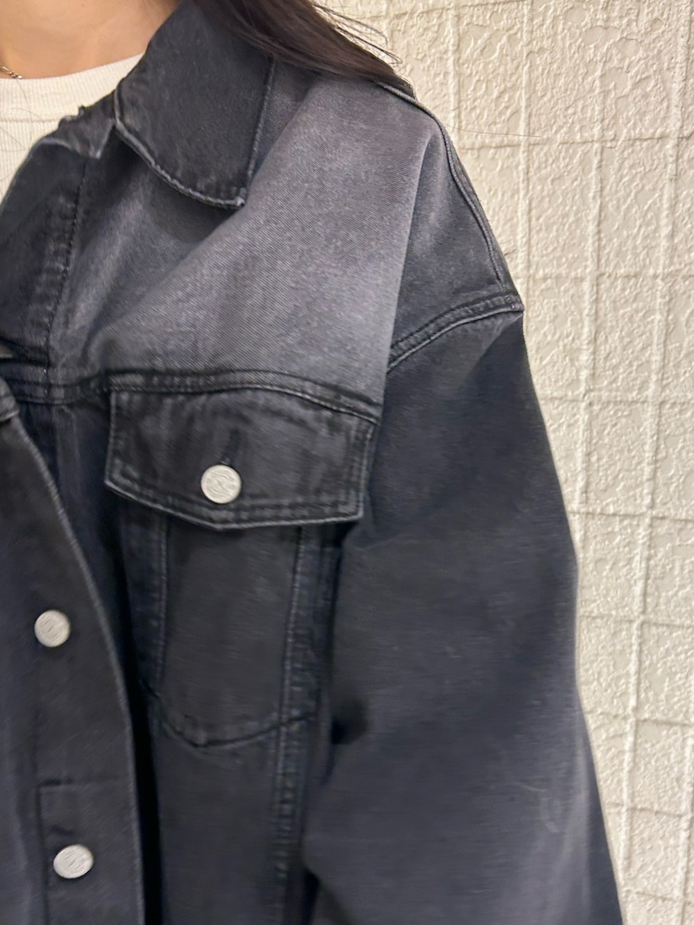 ブラック系のデニムジャケット、ホワイト系のTシャツ/カットソー、グレー系のスカートを着用したレディースの春コーディネートの5枚目の写真