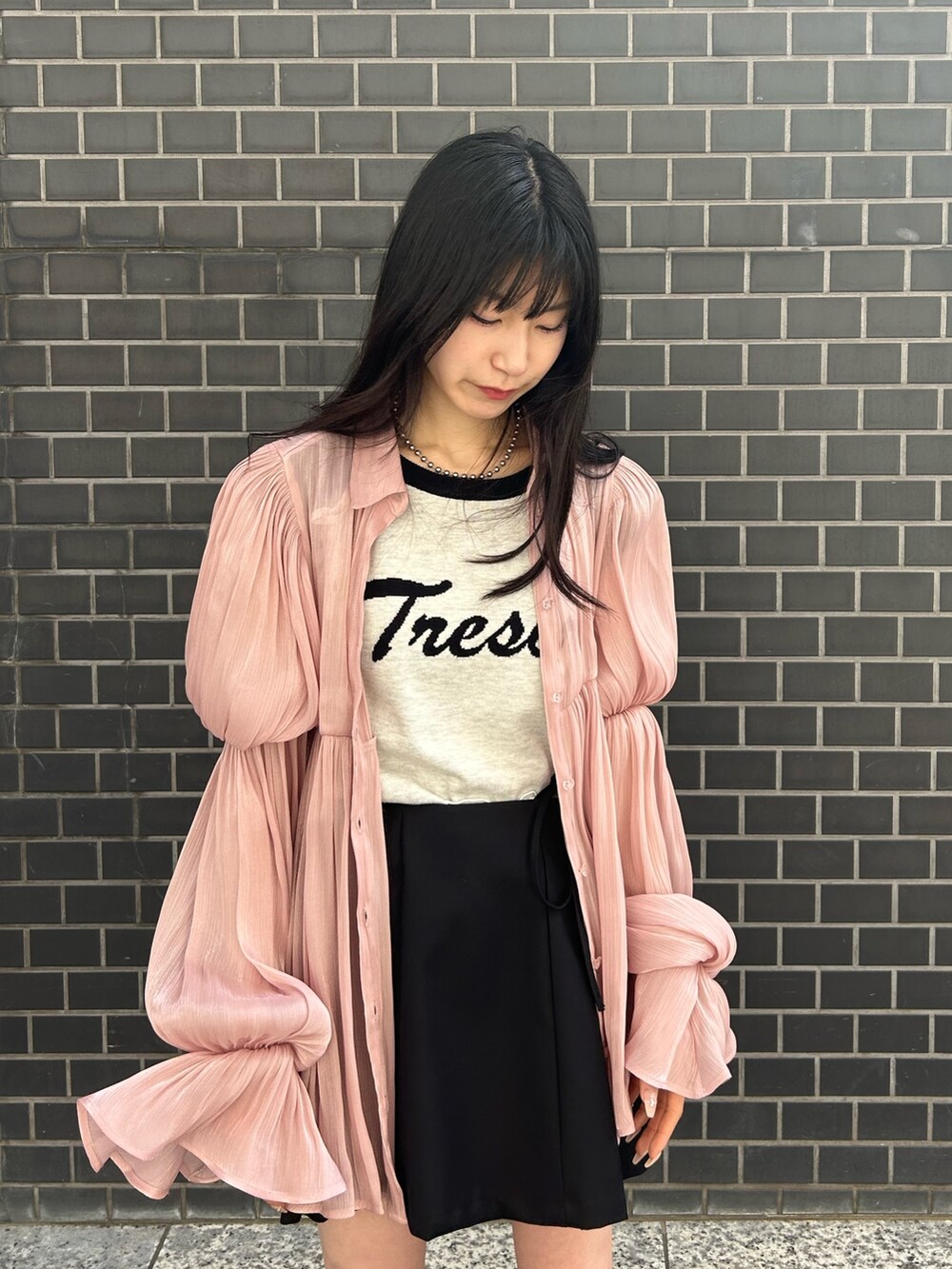 ピンク系のシャツ/ブラウス、ホワイト系のニット/セーター、ブラック系のスカートを着用したレディースの春コーディネートの4枚目の写真