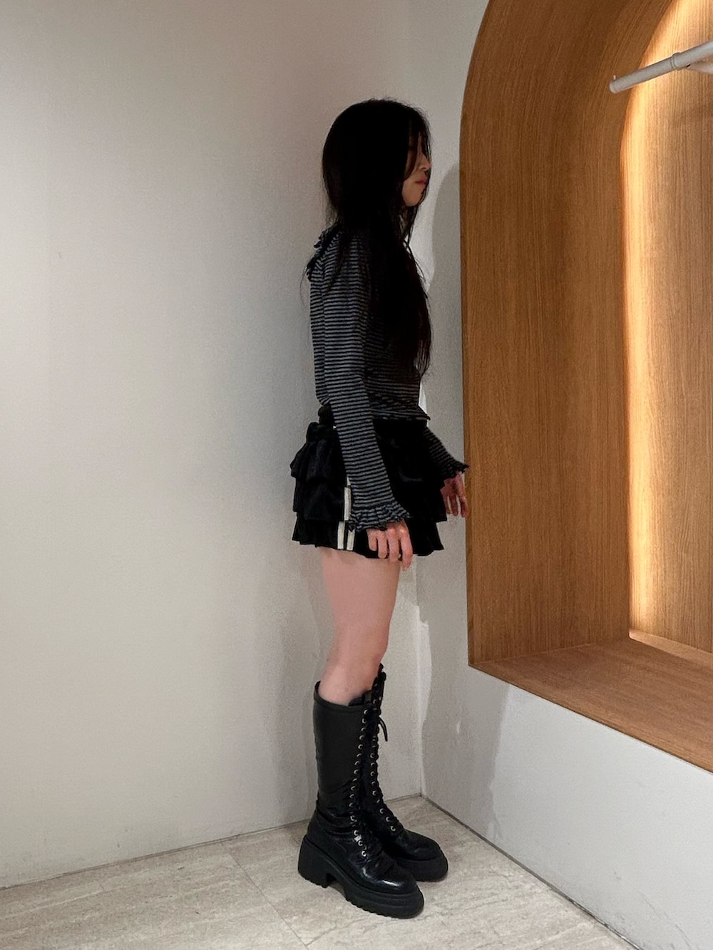 ブラック系のスカート、ブラック系のブーツ、ブラック系のTシャツ/カットソーを着用したレディースの秋コーディネートの2枚目の写真