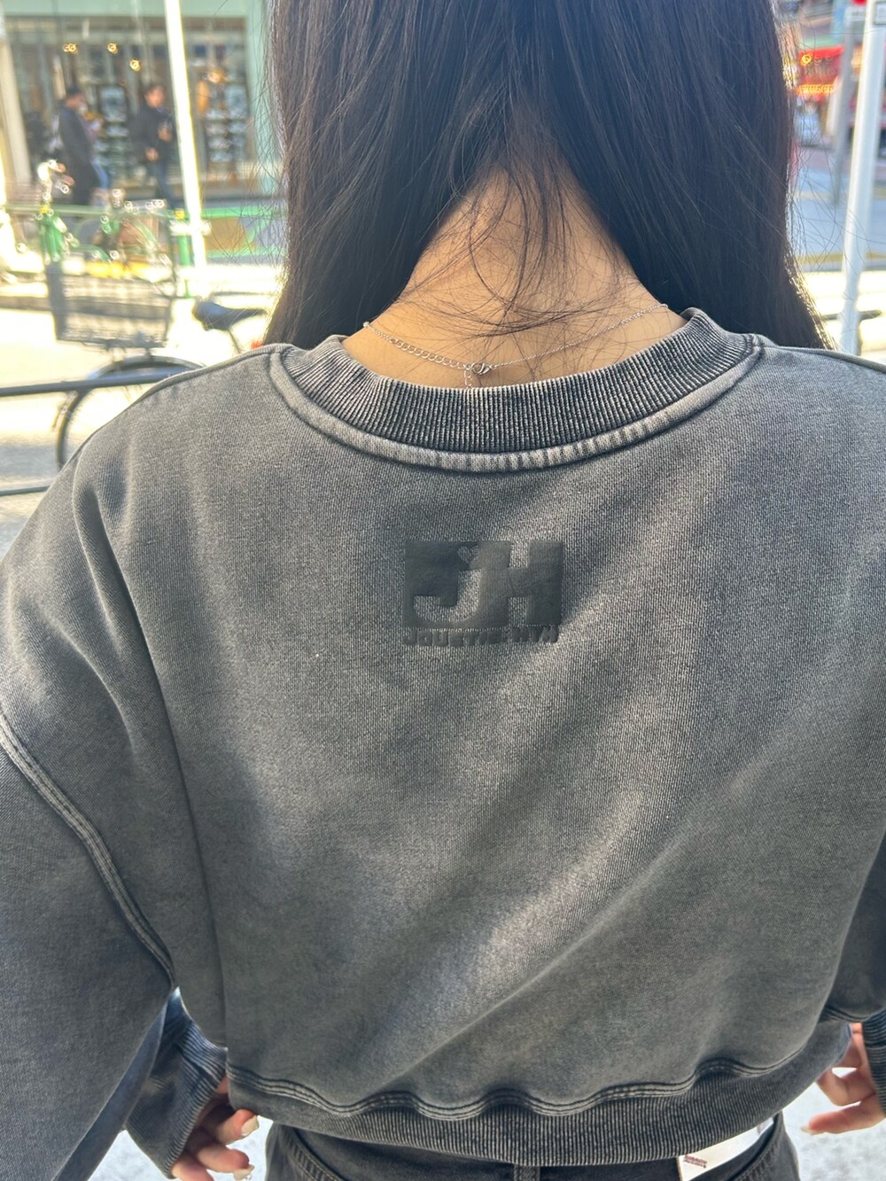 ブラック系のデニムパンツ、ブラック系のスウェット、ブラック系のパンプスを着用したレディースの冬コーディネートの7枚目の写真