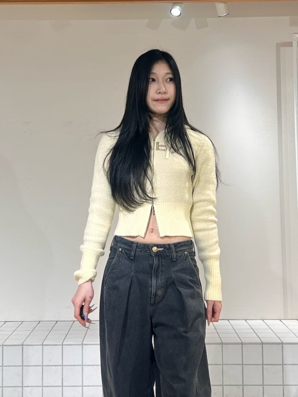 ブラック系のパンプス、ブルー系のデニムパンツ、イエロー系のパーカーを着用したレディースの冬コーディネートの4枚目の写真