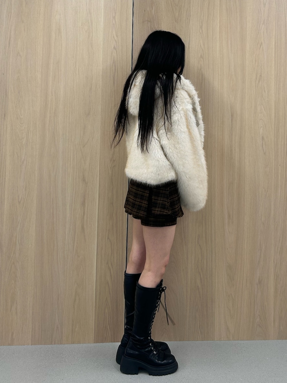 ホワイト系のブルゾン、ブラウン系のスカート、ブラック系のブーツを着用したレディースの秋コーディネートの2枚目の写真