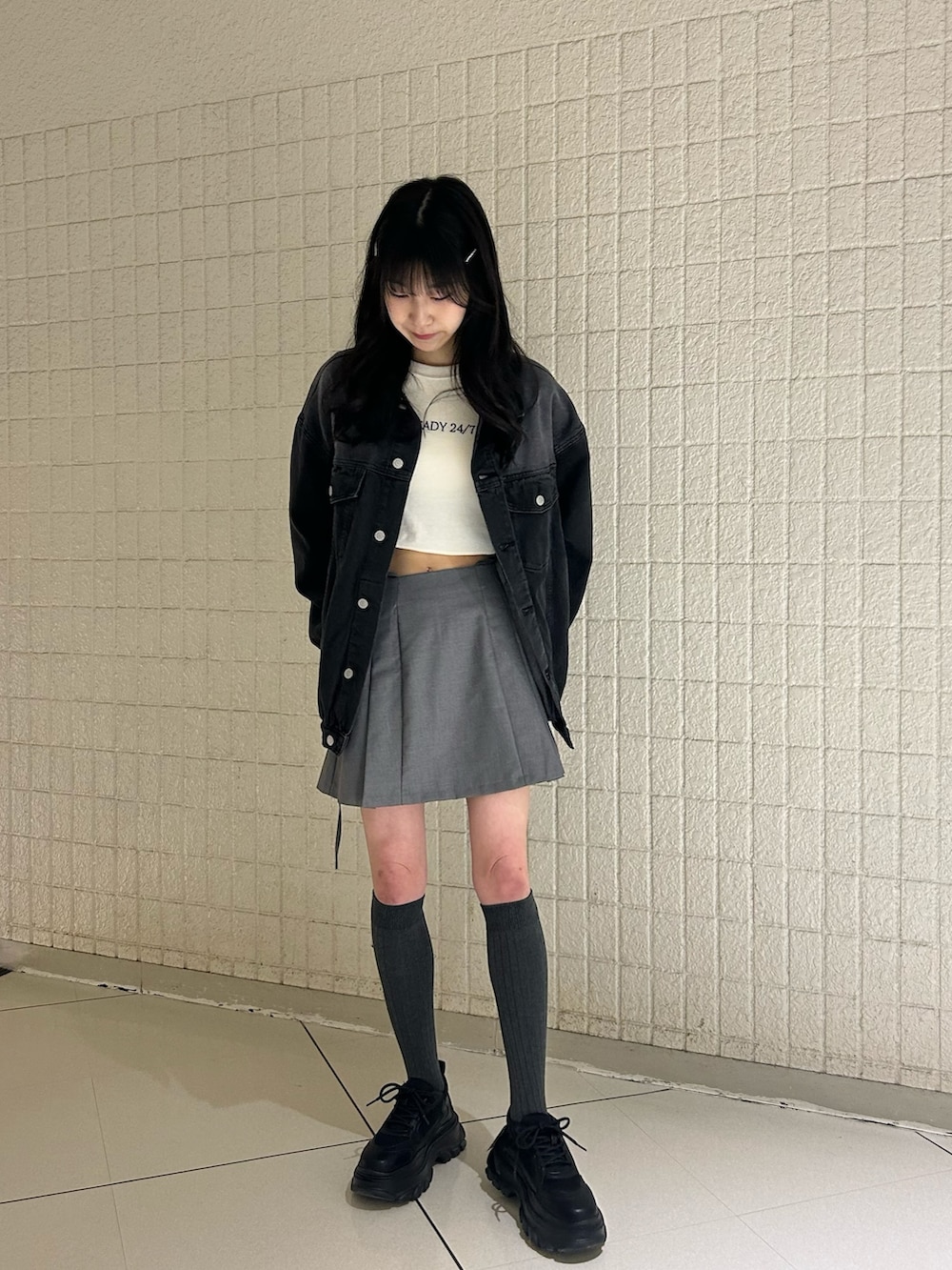 ブラック系のデニムジャケット、ホワイト系のTシャツ/カットソー、グレー系のスカートを着用したレディースの春コーディネートの2枚目の写真