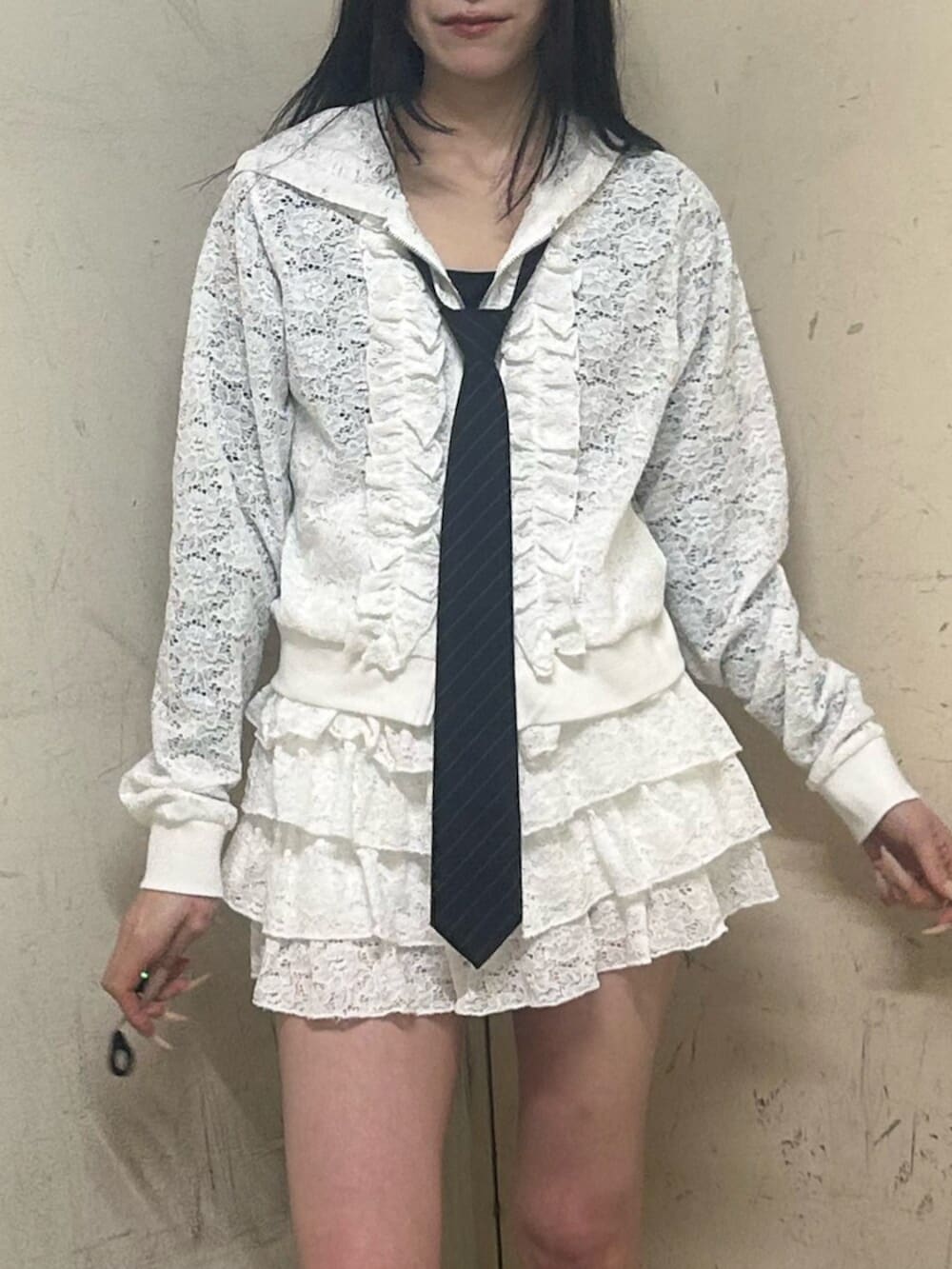 ブラック系のブーツ、ホワイト系のパーカー、ホワイト系のスカートを着用したレディースの春コーディネートの5枚目の写真