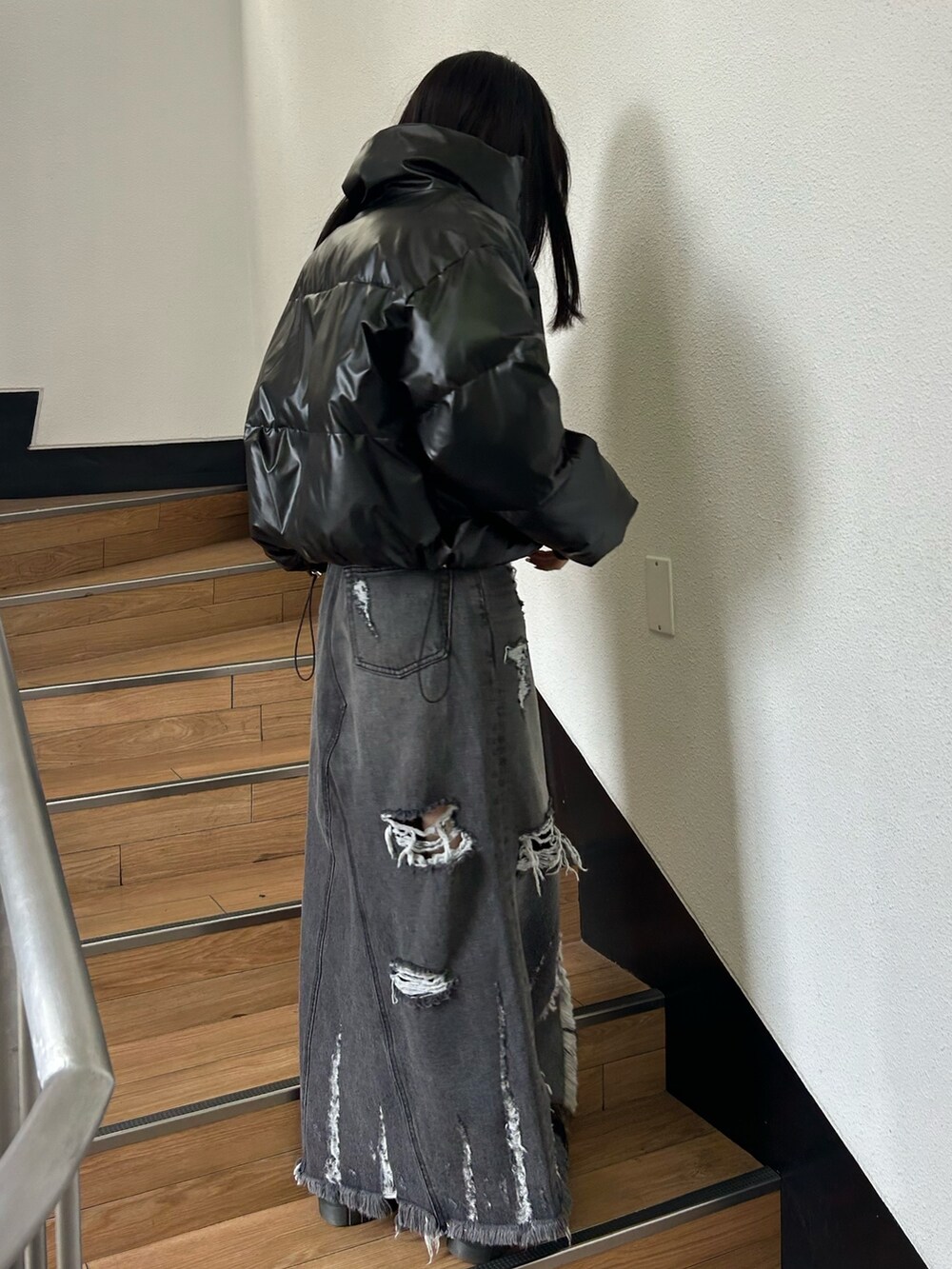 ブラック系のダウンジャケット/コート、ブラック系のニット/セーター、ブラック系のデニムスカートを着用したレディースの冬コーディネートの2枚目の写真