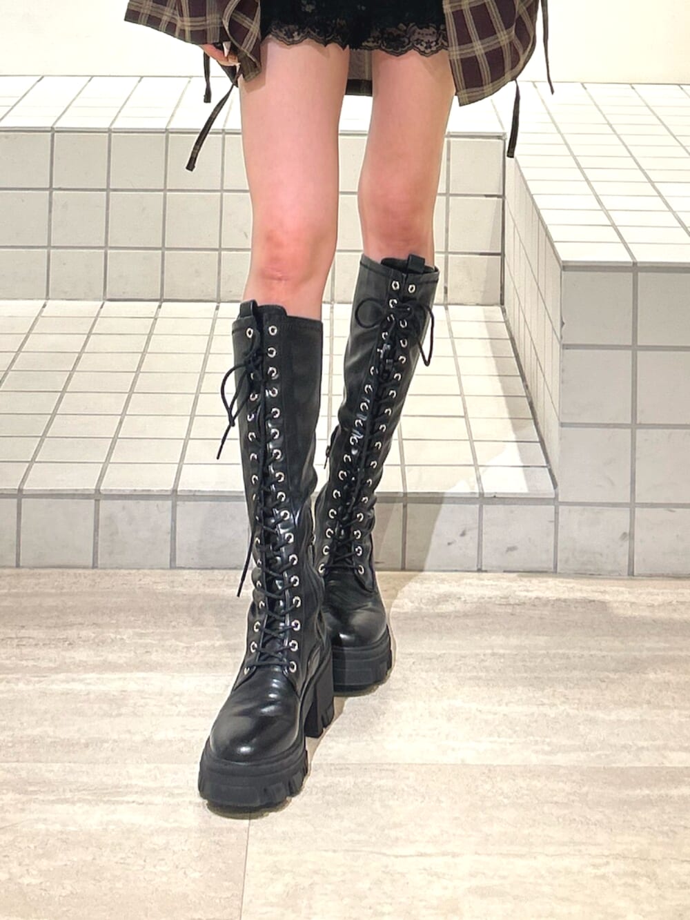 ホワイト系のキャミソール、ブラック系のブーツ、ブラック系のその他パンツを着用したレディースの秋コーディネートの9枚目の写真