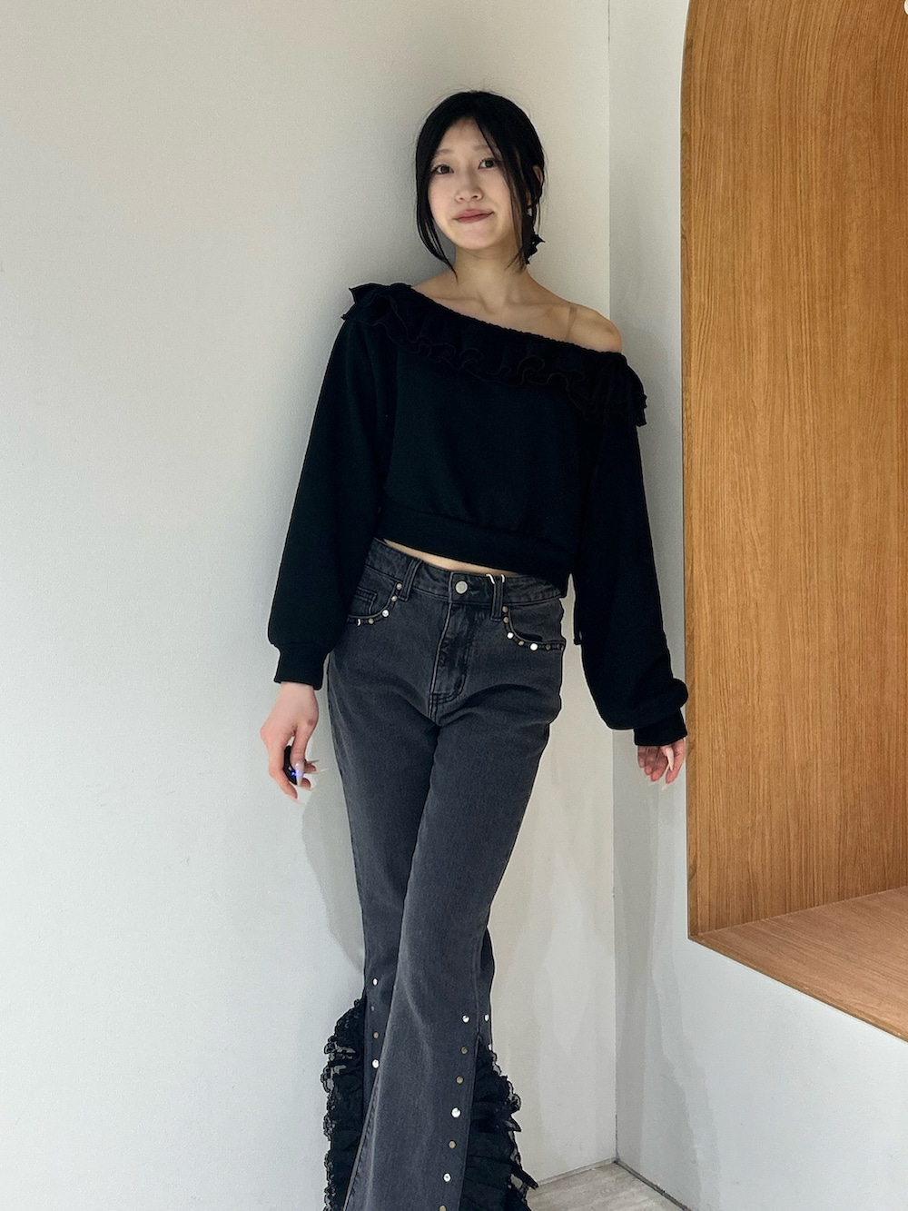 ブラック系のスウェット、ブラック系のデニムパンツ、ブラック系のパンプスを着用したレディースの冬コーディネートの4枚目の写真