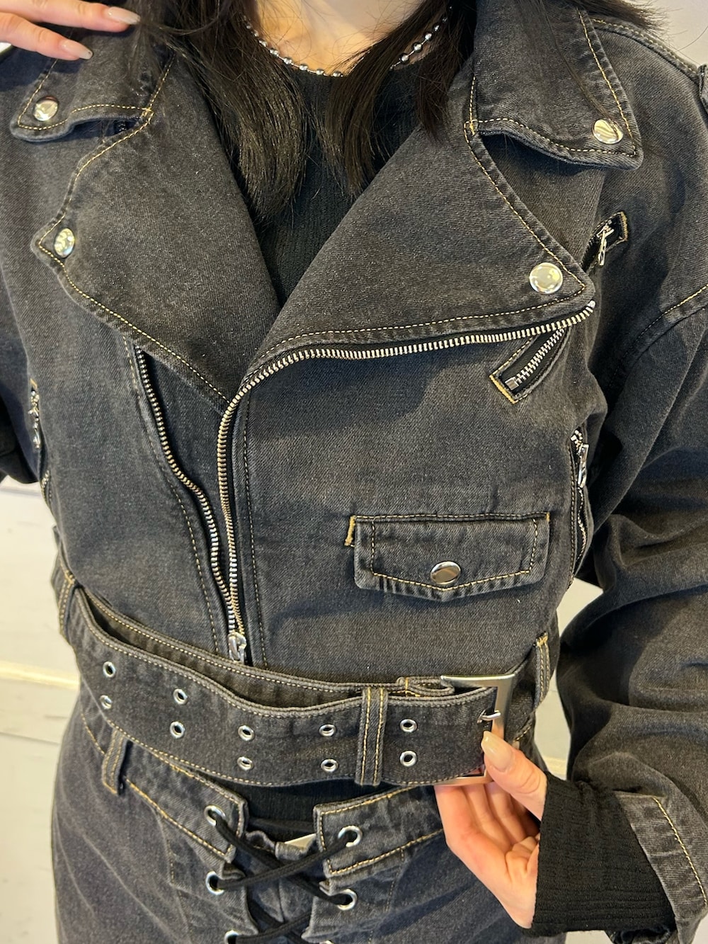 ブラック系のデニムパンツ、ブラック系のライダースジャケットを着用したレディースの秋コーディネートの6枚目の写真