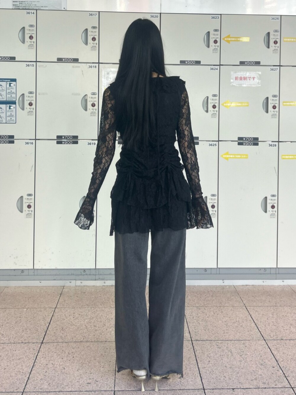 ゴールド系のパンプス、ブラック系のワンピース、ブラック系のデニムパンツを着用したレディースの冬コーディネートの3枚目の写真