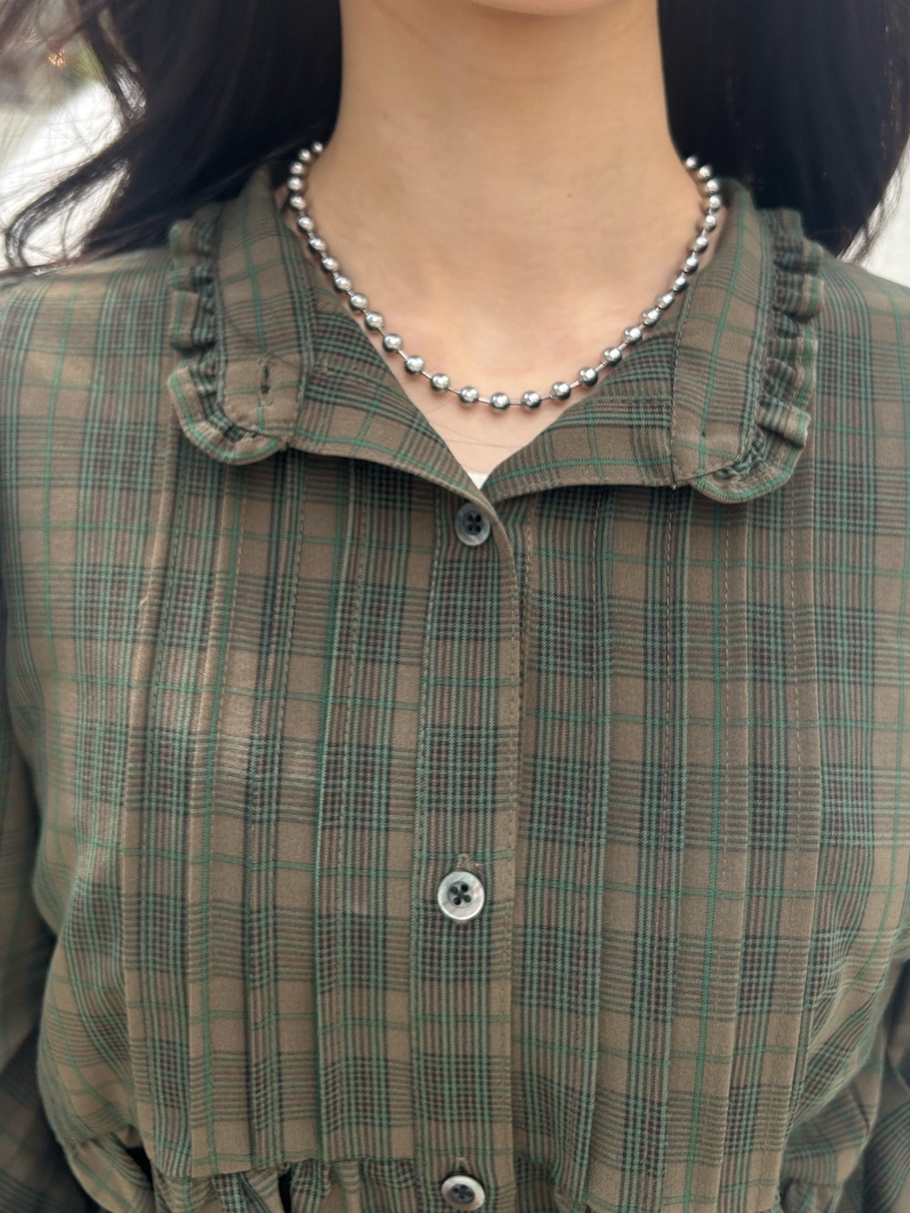 グリーン系のワンピース、ブルー系のデニムパンツ、ブラック系のベルトを着用したレディースの夏コーディネートの4枚目の写真