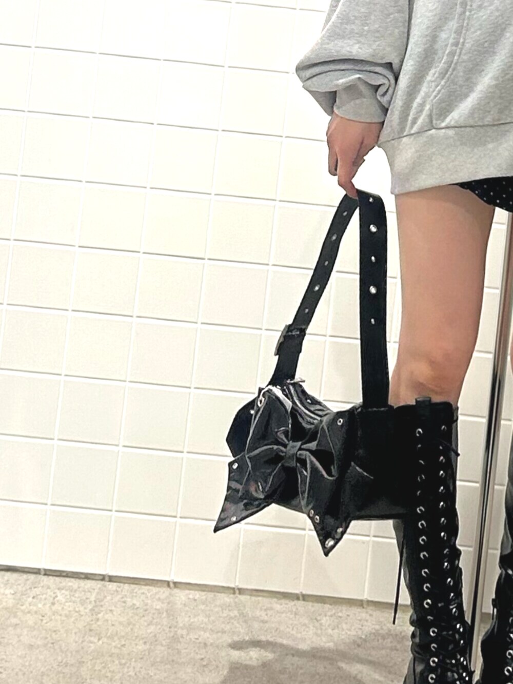 ブラック系のブーツ、グレー系のパーカー、ブラック系のスカートを着用したレディースの秋コーディネートの7枚目の写真