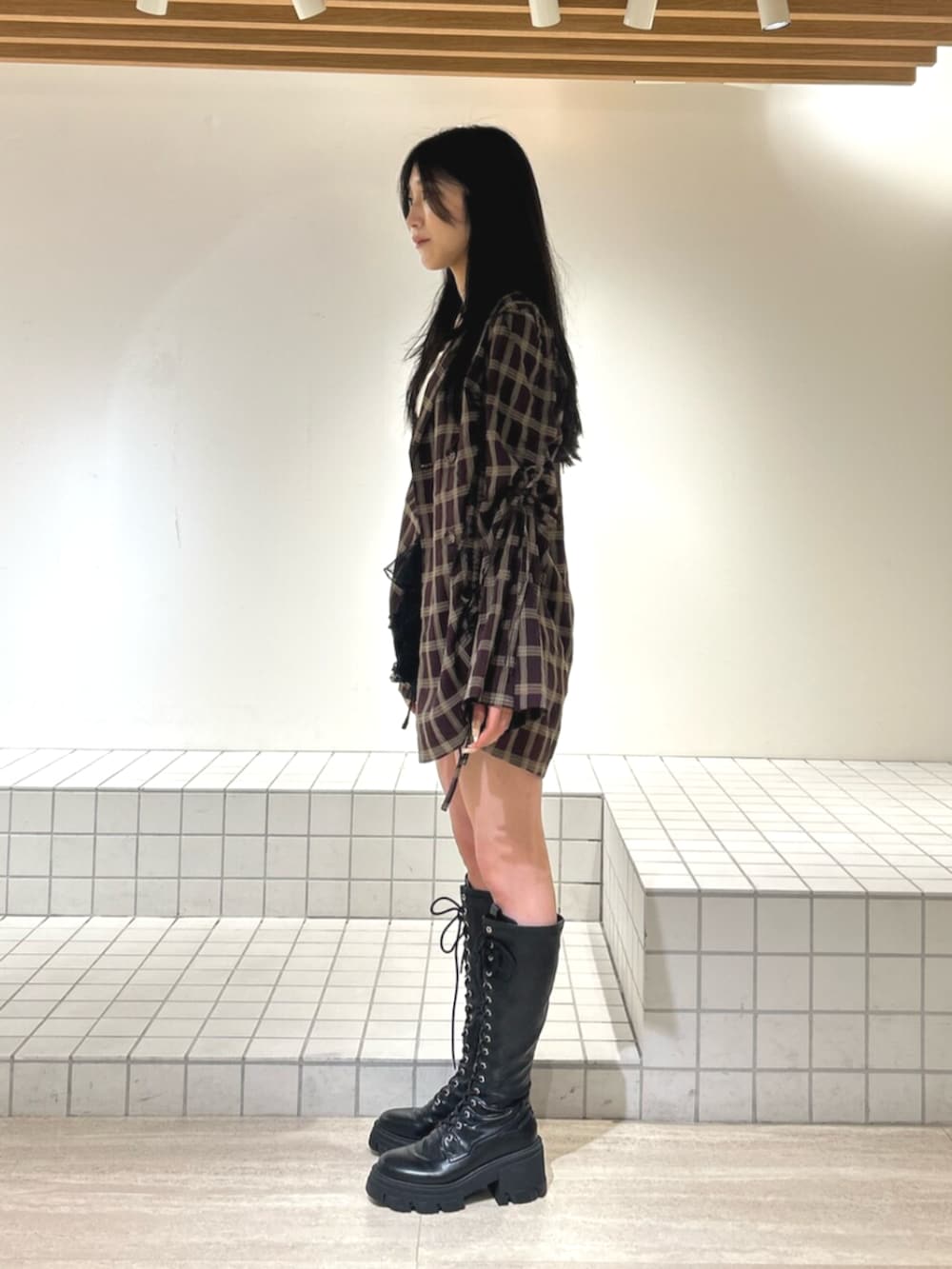 ホワイト系のキャミソール、ブラック系のブーツ、ブラック系のその他パンツを着用したレディースの秋コーディネートの2枚目の写真