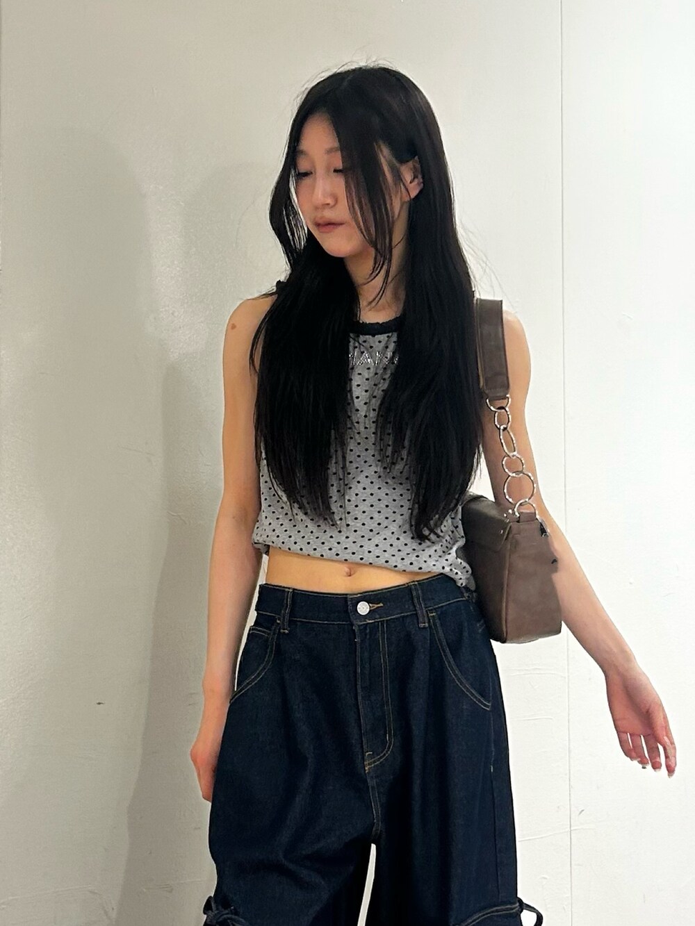 グリーン系のパンプス、グレー系のタンクトップ、ブルー系のデニムパンツを着用したレディースの夏コーディネートの4枚目の写真