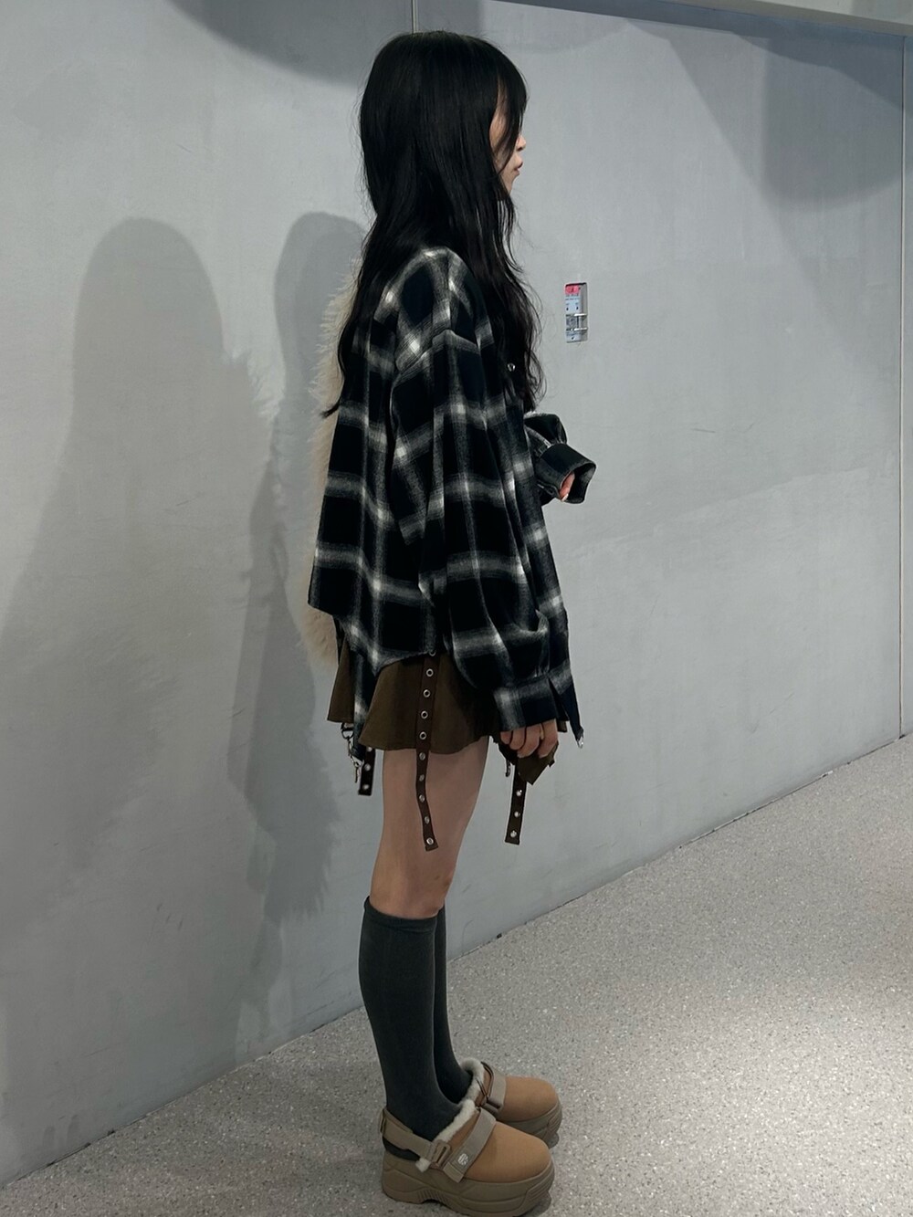 ホワイト系のショルダーバッグ、ベージュ系のブーツ、ブラウン系のスカートを着用したレディースの秋コーディネートの4枚目の写真