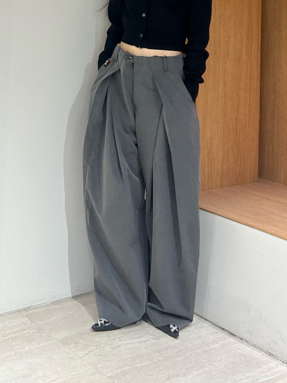 ブラック系のパンプス、グレー系のスラックス、ブラック系のカーディガン/ボレロを着用したレディースの春コーディネートの6枚目の写真