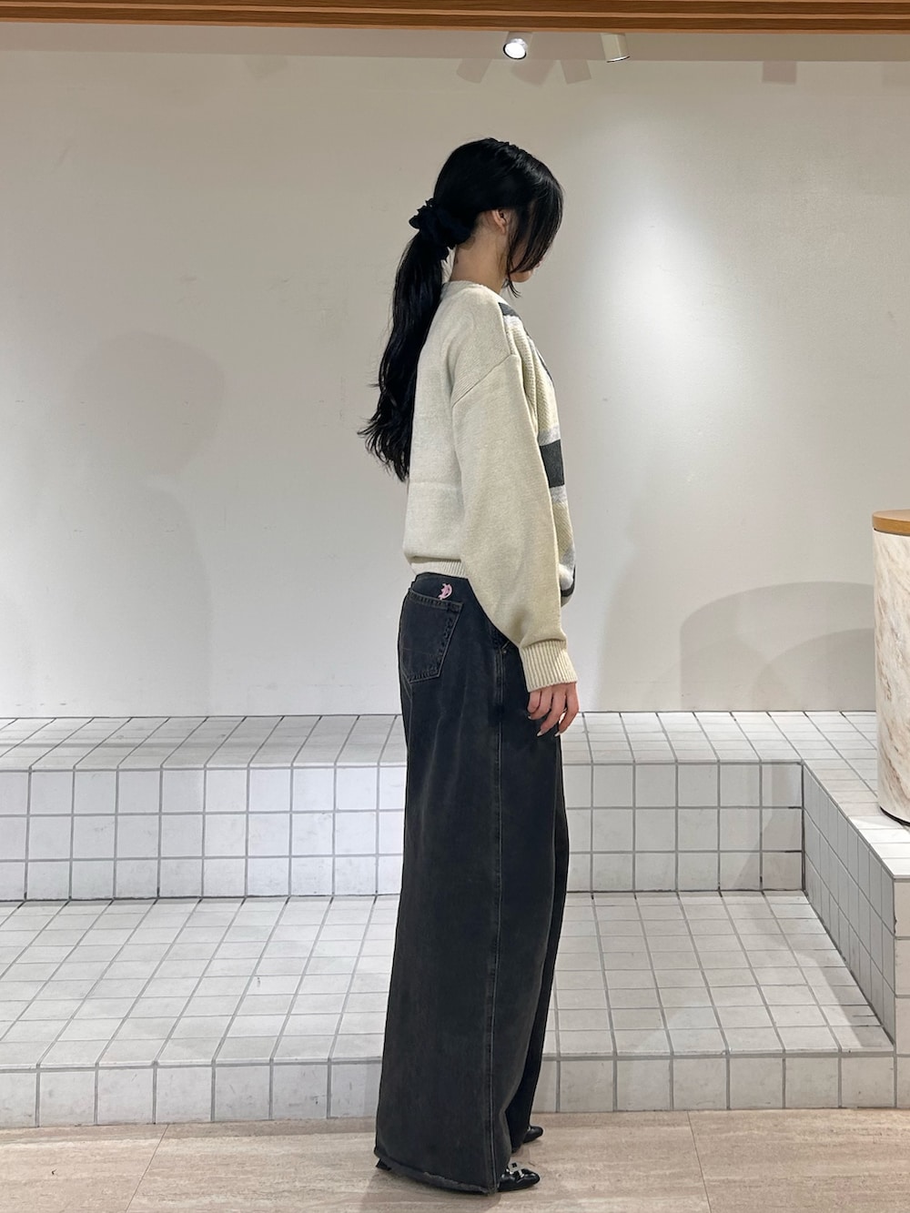 ホワイト系のニット/セーター、ブルー系のデニムパンツ、ブラック系のパンプスを着用したレディースの冬コーディネートの2枚目の写真